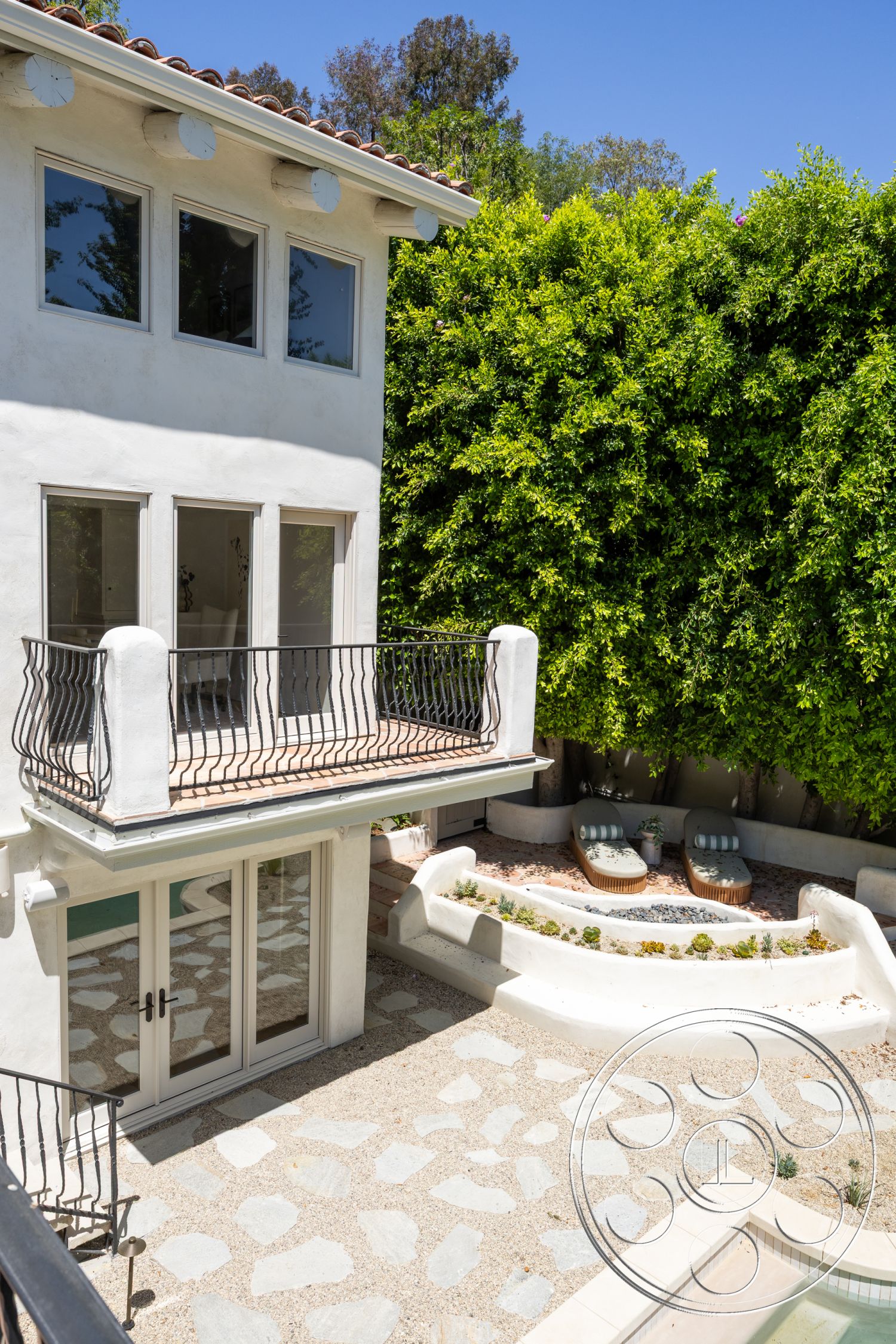 Medit 168 - exterior, floor-to-ceiling windows, stucco walls, terracotta tile roof, glass patio doors, two-story home, exposed wood ceiling beams, curved seating area, slate patio flooring, urban backyard setting, wrought iron balcony railing, landscaped garden with succulents
