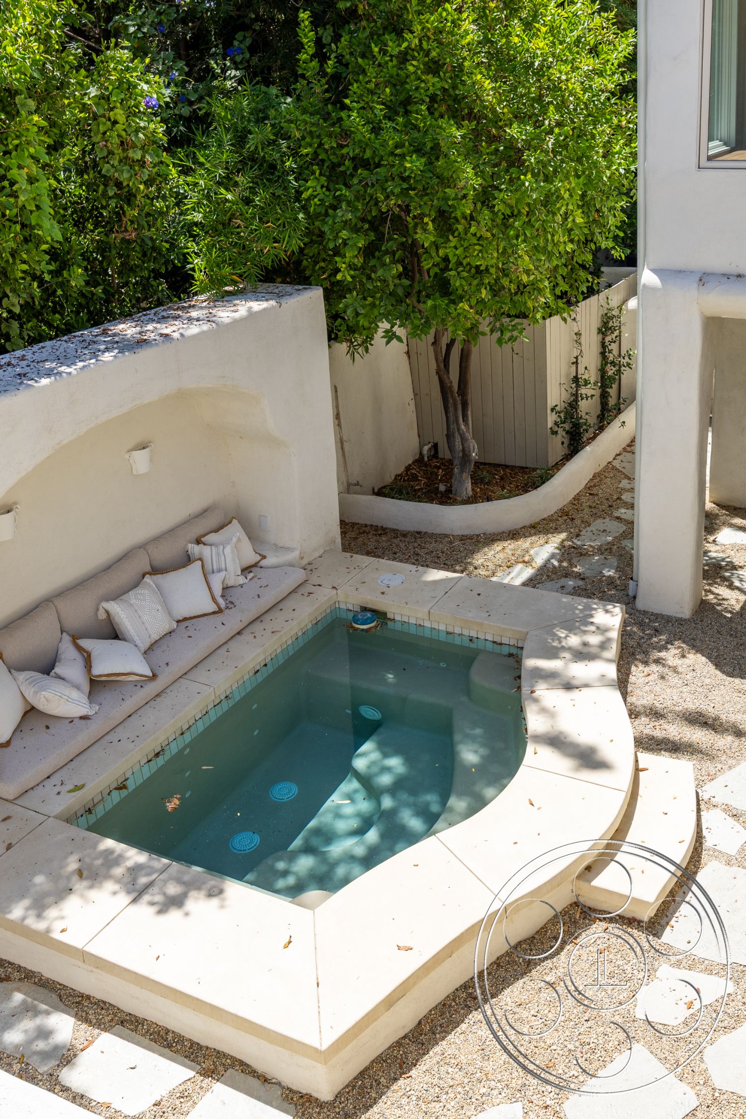 Medit 168 - exterior, lush greenery, landscaped backyard, plunge pool, integrated seating area, gravel garden path, tile pool border, decorative outdoor cushions, concrete patio surround, natural stone pool coping, rounded shapes, shaded pool area
