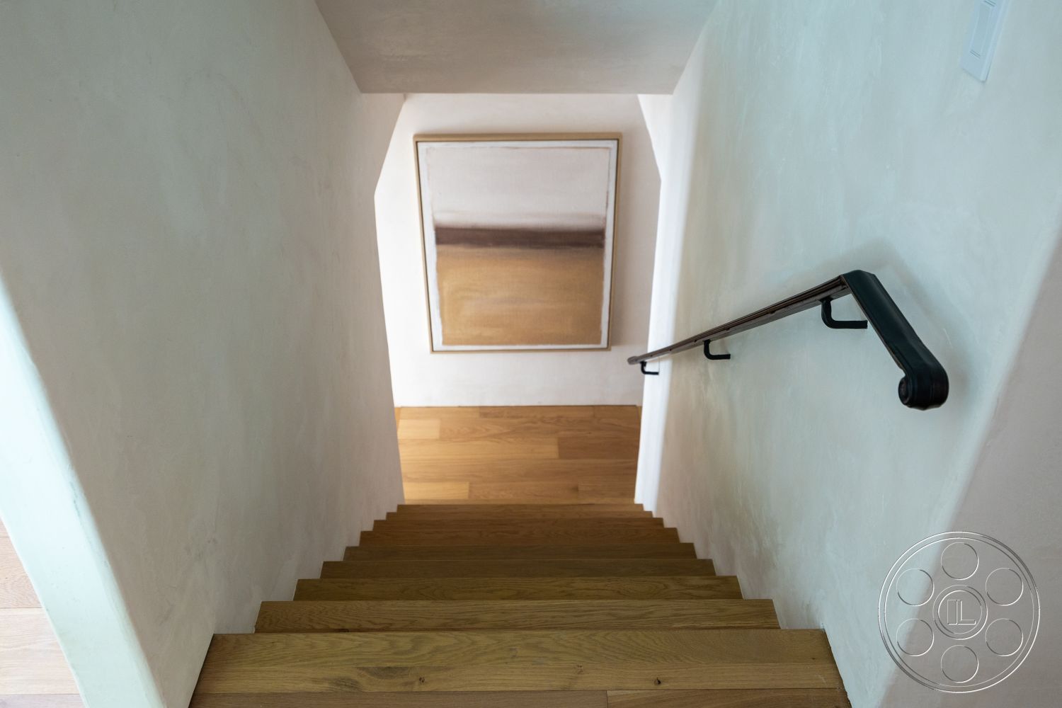 Medit 168 - minimalist design, white plaster walls, hardwood staircase, black metal handrail, rectangular artwork