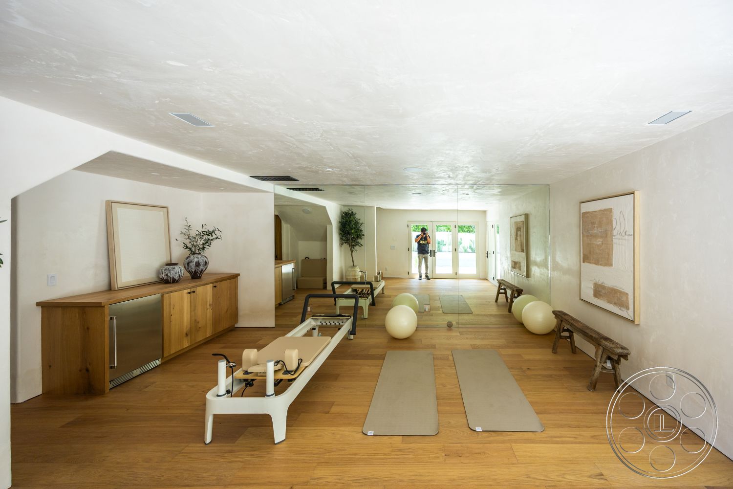 Medit 168 - light wood flooring, potted plants, natural wood cabinetry, glass sliding doors, decorative wall art, vaulted ceiling, mirrored wall, smooth plaster walls, minimalist workout space