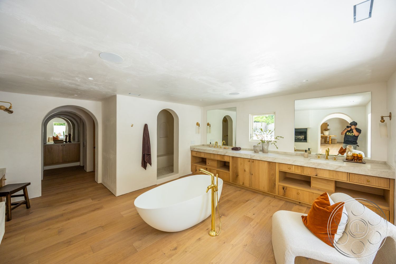 Medit 168 - neutral color palette, white marble countertop, arched doorways, textured wall finishes, natural light from windows, minimalist decorative accents, exposed plaster walls, freestanding soaking bathtub, oak hardwood flooring, quarter-sawn oak bathroom vanities, modern gold faucet fixtures, large rectangular mirrors, designer accent chair