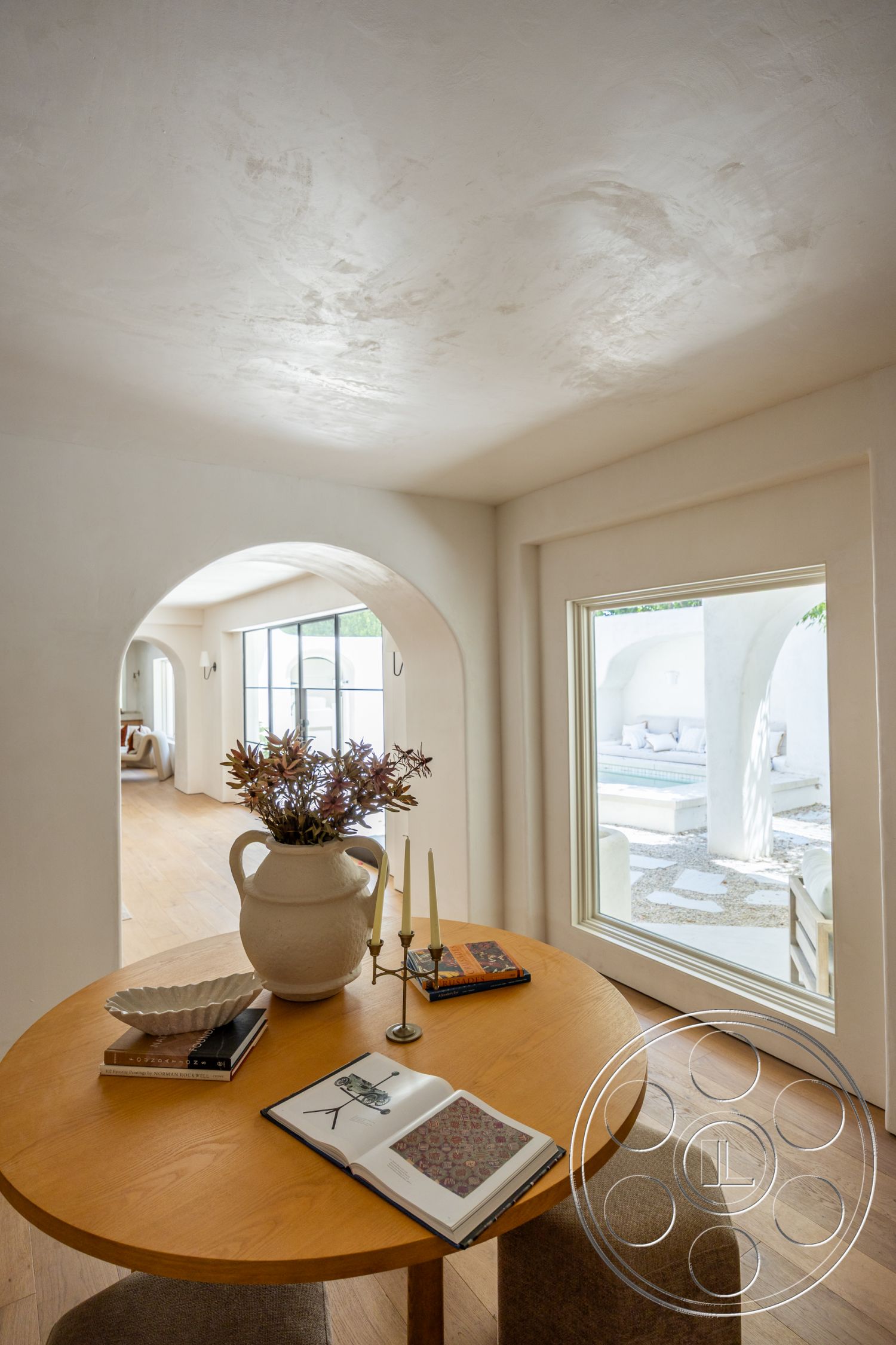 Medit 168 - minimalist decor, hardwood flooring, exterior, arched doorways, textured plaster walls, contemporary interior design, round wooden dining table, ceramic vase with flowers, natural light ambiance, glass window with view