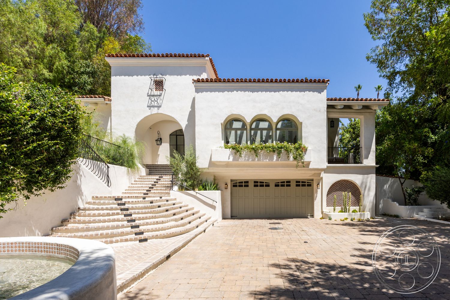 Medit 168 - exterior, paver driveway, stucco walls, arched doorways, red clay tile roof, arched windows, stone planters, wrought iron railing, landscaped garden setting, curved steps