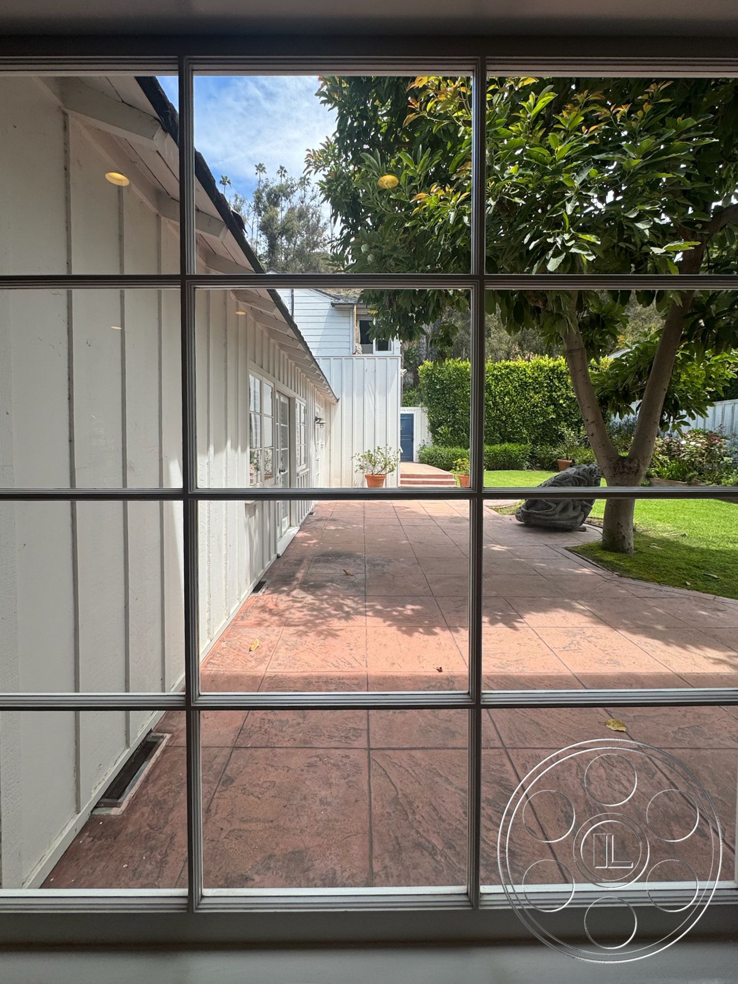 Lloyd Beach House - exterior, landscaped garden, potted plants, white wooden siding, clear blue sky, ornamental trees, sloping green lawn, textured concrete patio flooring
