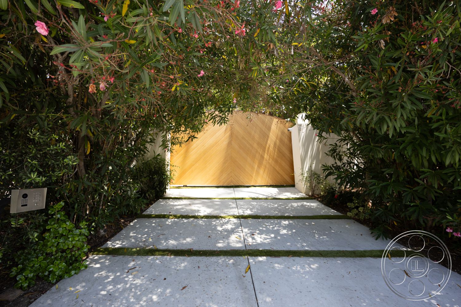 Americana 434 - exterior, flowering bushes, landscape plants, concrete driveway, private entrance, textured wooden wall, wooden gate, green grass strips, modern pathway design