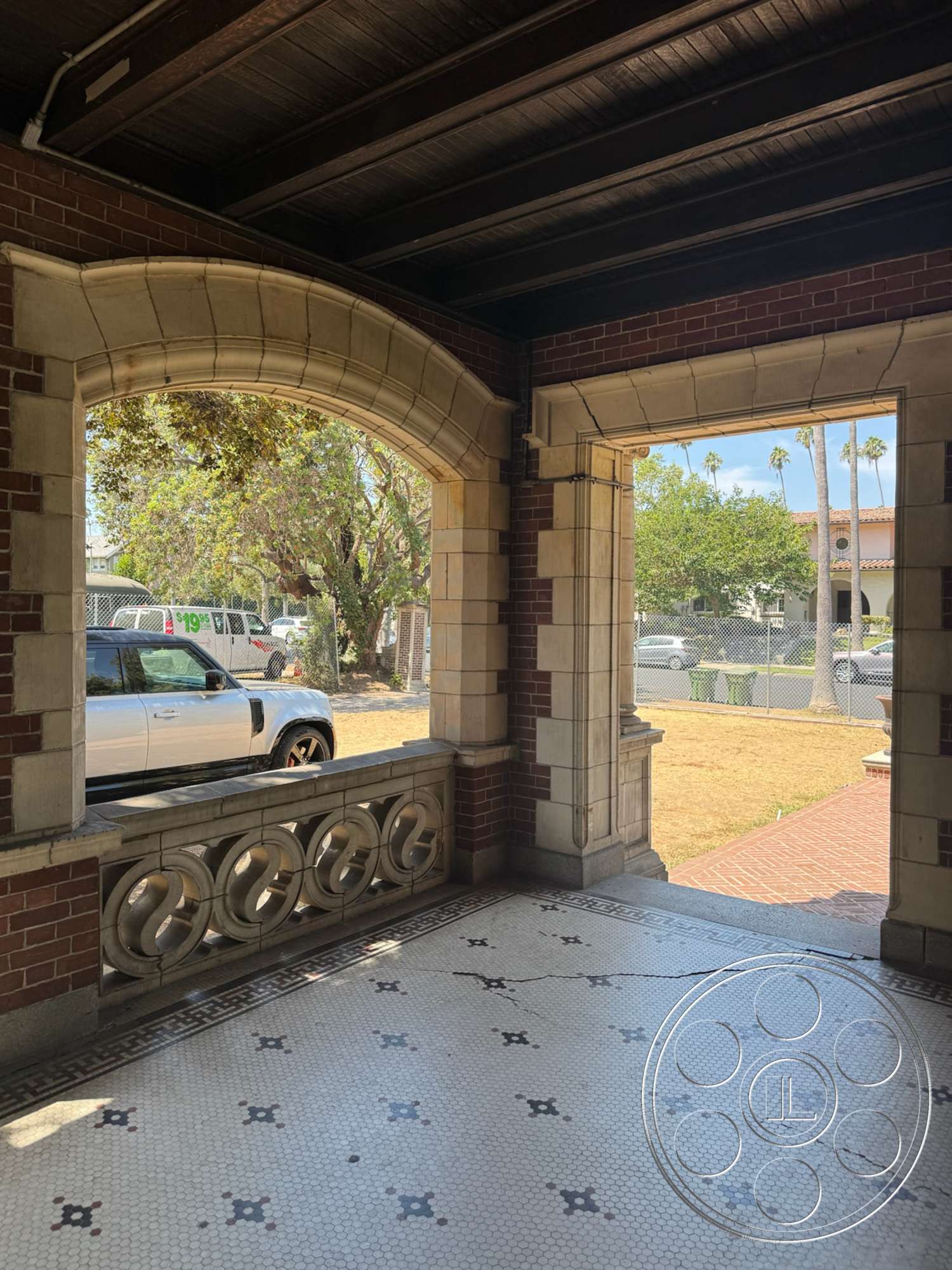 The Rosenheim Mansion - exterior, brick walls, urban setting, arched doorways, decorative stone balustrade, vaulted ceiling with wood beams, stone accent details, polished mosaic tile flooring, open porch entryway, view of palm trees