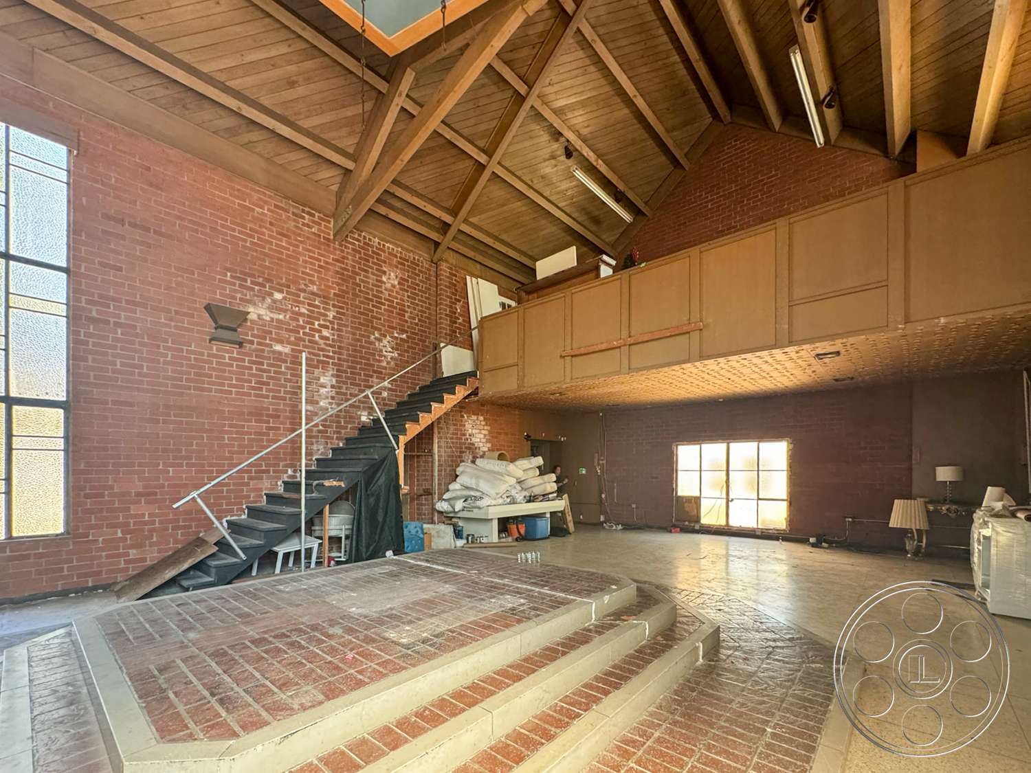 The Rosenheim Mansion - neutral color palette, large windows, natural light, open floor plan, industrial style, exposed brick walls, spiral staircase, unfinished space, elevated platform, wood beam ceiling, brick patio flooring, metal stair railings, wooden balcony railing, laminated wood ceiling