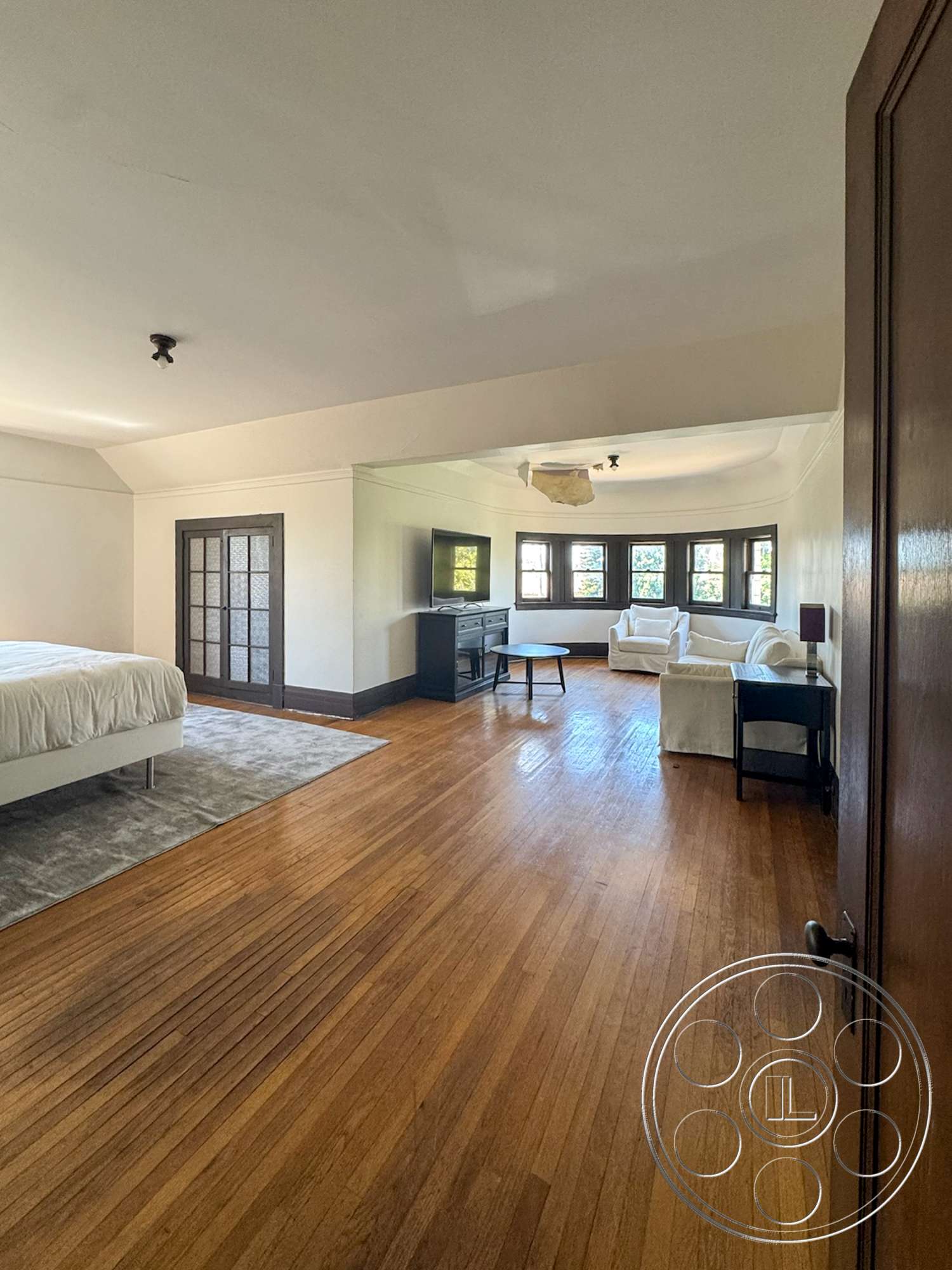 The Rosenheim Mansion - modern furniture, area rug, exposed ceiling beams, painted walls, bay windows, hardwood bedroom floors