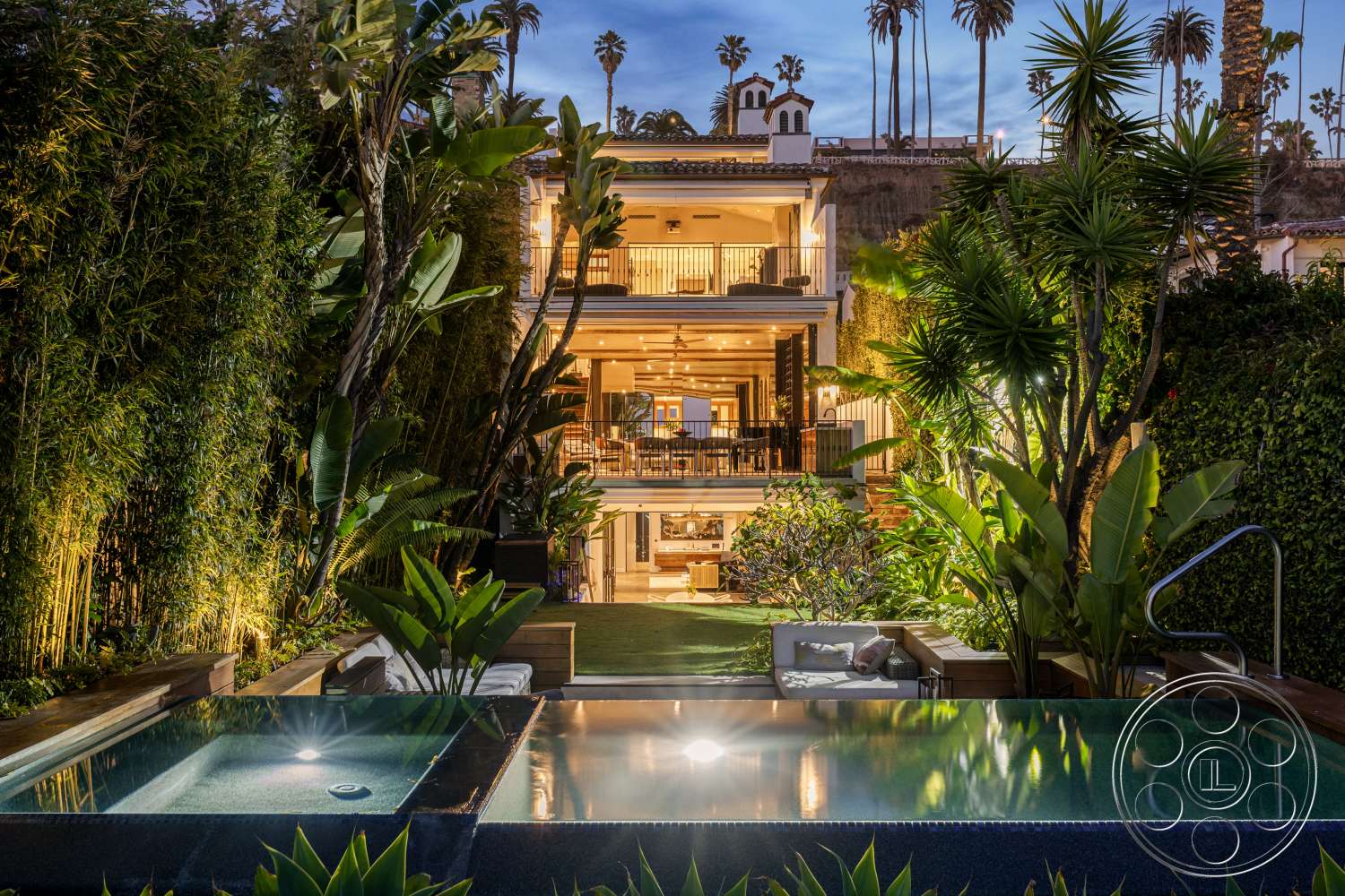 Beach 137 - exterior, palm trees, open floor plan, outdoor seating area, floor-to-ceiling windows, city skyline view, tropical landscaping, bamboo privacy screen, wood deck patio, multi-story home, stone water feature, modern house facade, rectangular spa, luxury swimming pool, illuminated garden