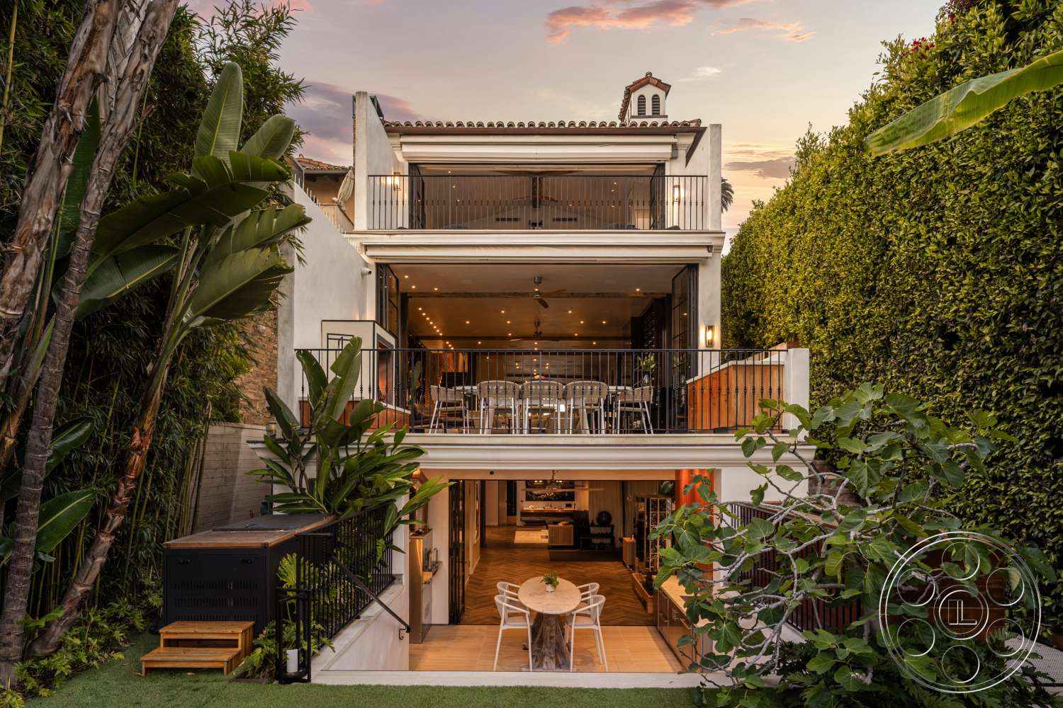 Beach 137 - exterior, palm trees, floor-to-ceiling windows, modern architectural style, stucco walls, lush tropical landscaping, large sliding glass doors, outdoor entertainment area, two-story home, concrete patio flooring, urban garden setting, wooden outdoor dining table, metal railing balconies, flat roof with tile accents