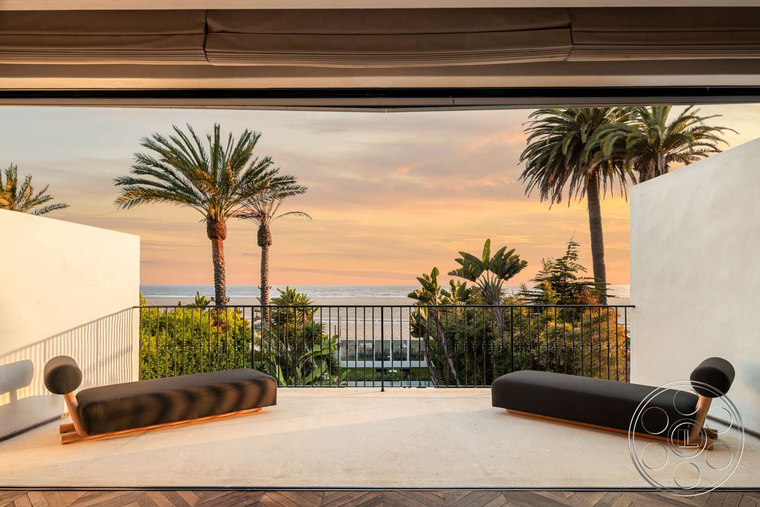 Beach 137 - exterior, natural wood accents, wood railing, minimalist seating, open-air design, white plaster walls, concrete patio flooring, palm tree landscaping, horizontal sliding glass doors, sunset ocean view
