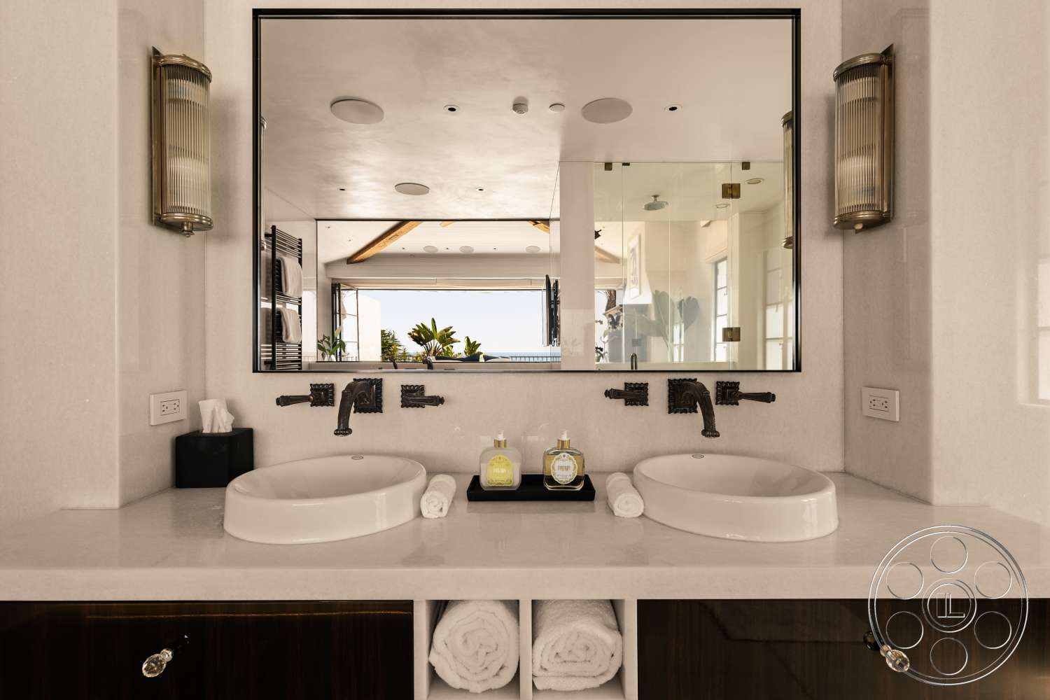 Beach 137 - dark wood cabinetry, neutral color palette, minimalist aesthetic, open concept design, floor-to-ceiling windows, textured plaster wall finish, marble bathroom countertop, brass faucet fixtures, spacious bathroom layout, white oval sinks, large mirror with black frame, wall-mounted light sconces