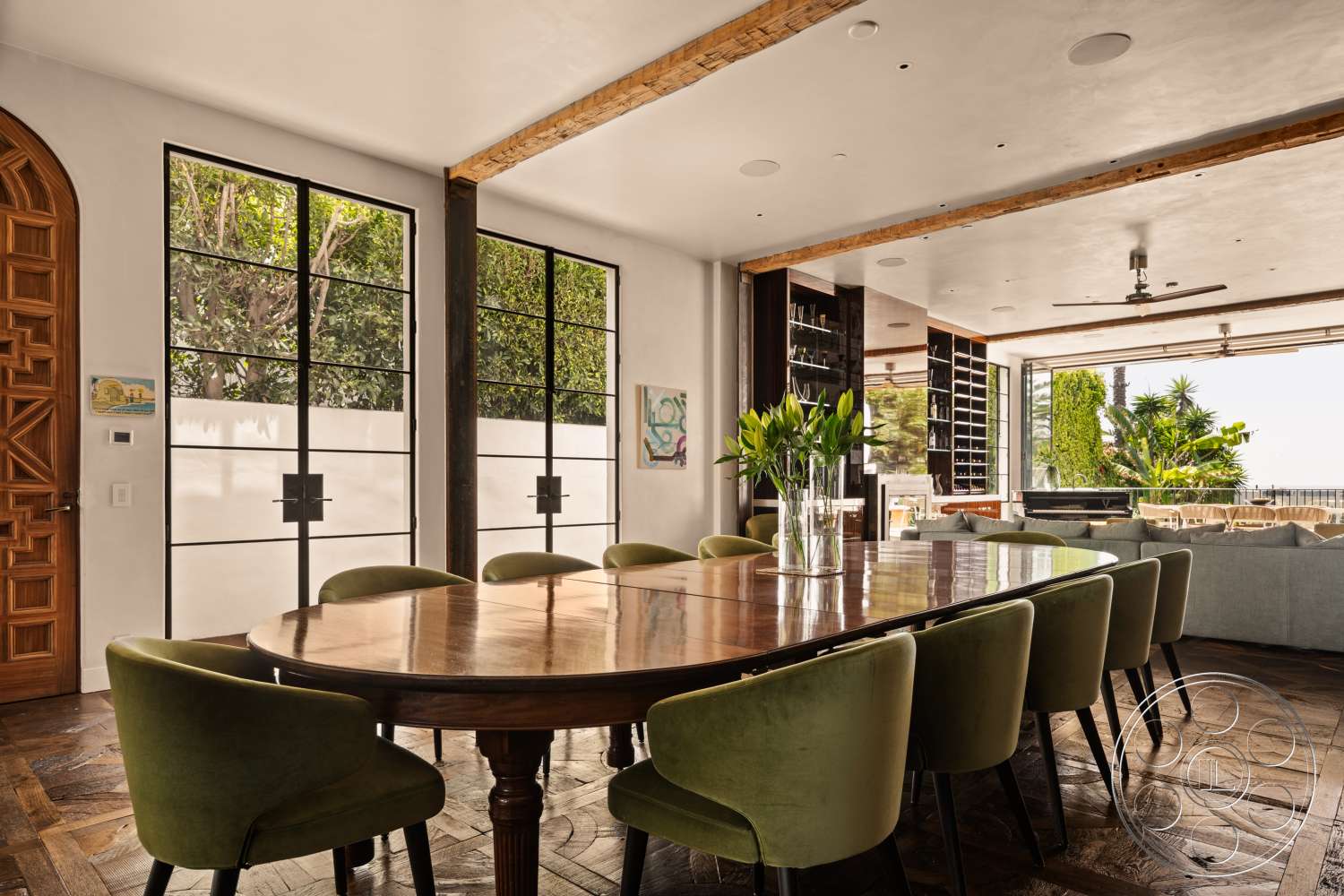 Beach 137 - natural light, indoor plants, wood dining table, floor-to-ceiling windows, open-concept layout, decorative wooden door, exposed wood ceiling beams, artwork wall display, built-in shelving unit, green upholstered dining chairs, textured hardwood flooring, modern glass wall partitions