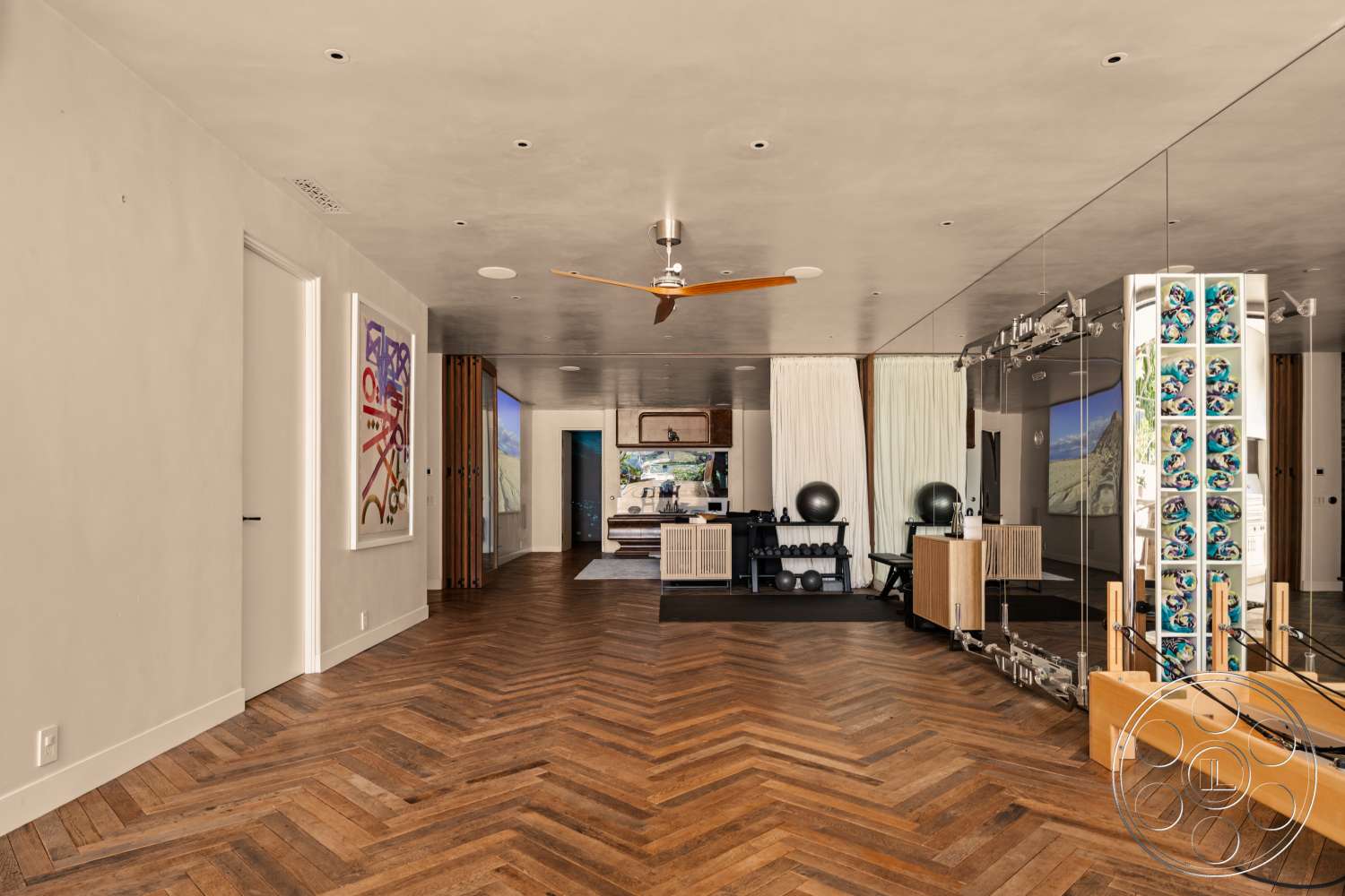 Beach 137 - minimalist design, artistic wall decor, exercise area, open concept layout, textured plaster walls, exposed concrete ceiling, built-in cabinetry, modern ceiling fan, herringbone hardwood flooring, large windows with views, floor-to-ceiling mirrored wall