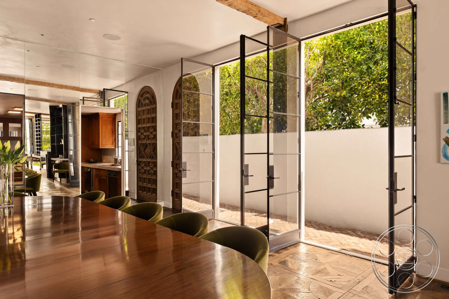 Beach 137 - dark wood cabinetry, natural light, wood dining table, outdoor view, textured plaster walls, herringbone wood flooring, exposed wood ceiling beams, mirror wall treatment, glass double doors, green velvet dining chairs, arched wooden doorways