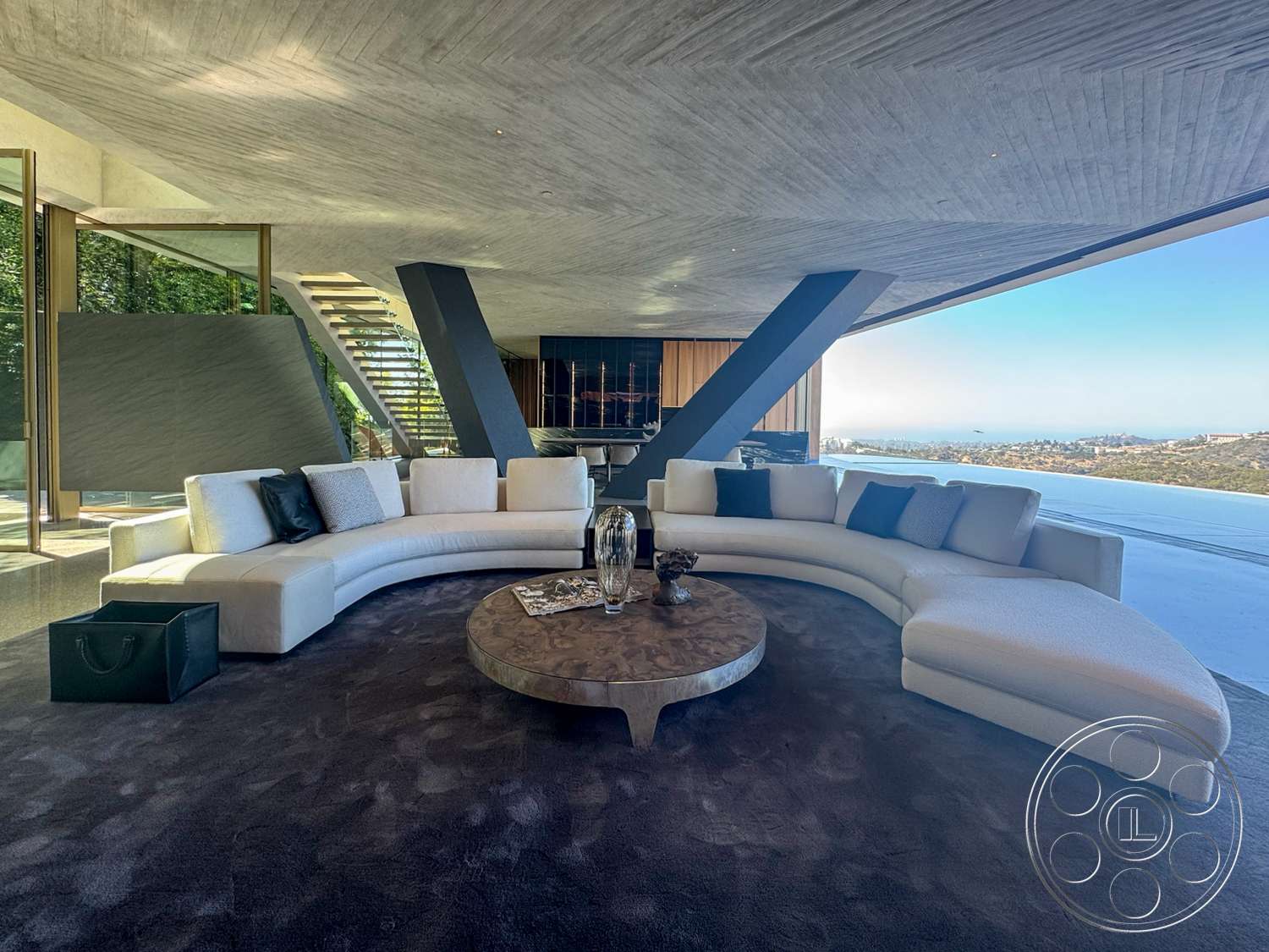 Modern 516 - open floor plan, minimalist design elements, panoramic view, modern architectural style, wood accent wall, exposed concrete ceiling, round wood coffee table, fabric upholstery, curved sectional sofa, glass wall panels, plush carpet flooring, multilevel staircase