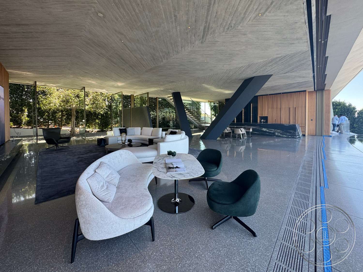 Modern 516 - minimalist design, round coffee table, open floor plan, modern furniture, wood paneling, polished concrete flooring, glass walls, black and white color scheme, geometric shapes, black accent chair, concrete ceiling, large sliding glass doors, curved sofa, expansive living area