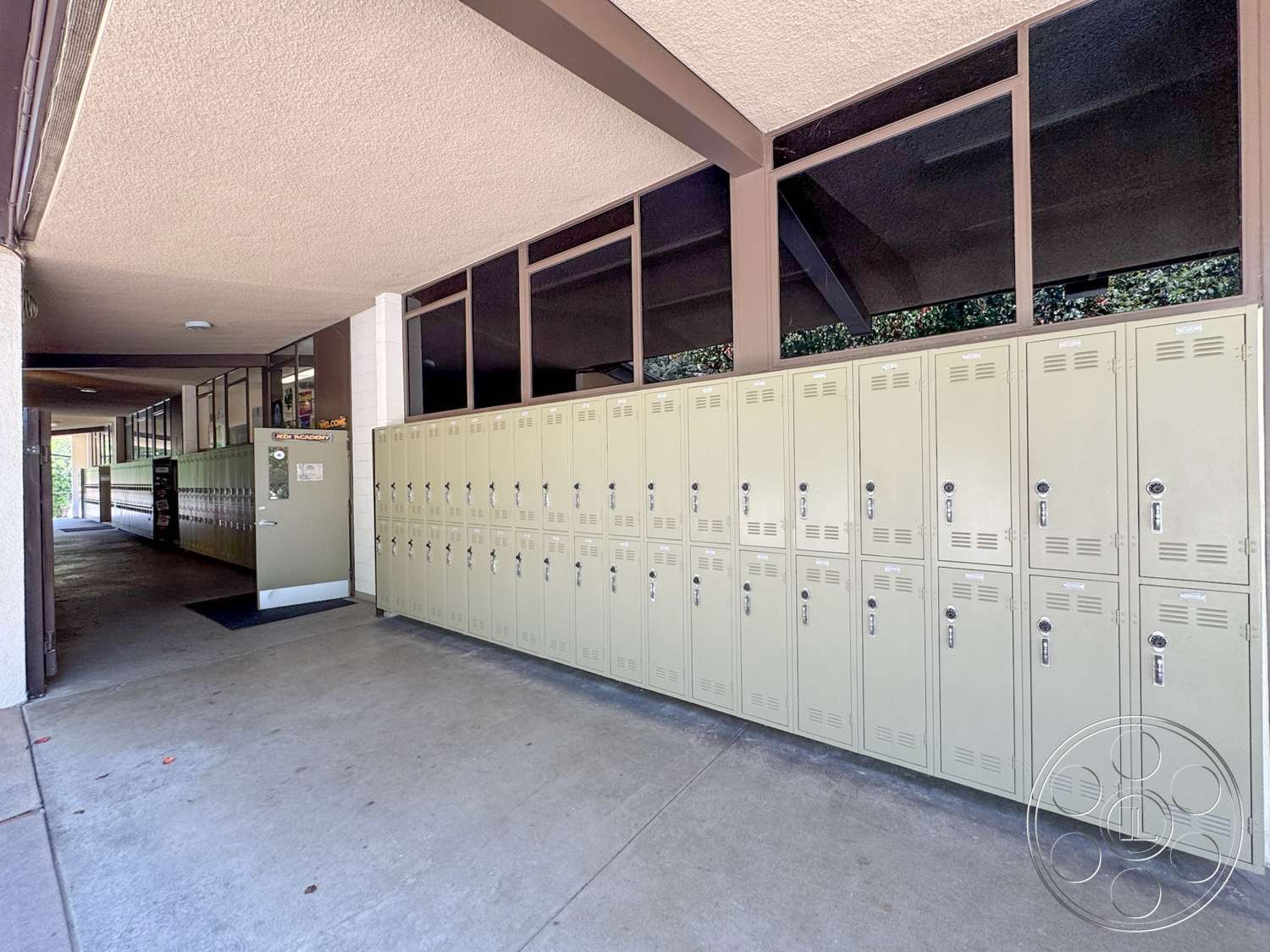 School 20 - exterior, concrete flooring, large glass windows, modern architectural style, metal lockers, open corridor design, painted cinder block walls, wooden support beams, functional school environment