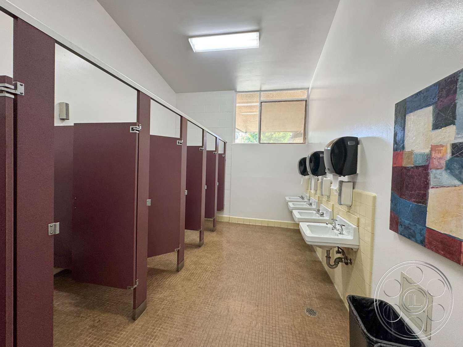 School 20 - chrome faucets, white painted walls, interior restroom, vinyl tile flooring, rectangular ceiling lights, mosaic floor tiles, maroon partition walls, stainless steel sinks, hand dryer wall-mounted, square basin design, window with horizontal blinds