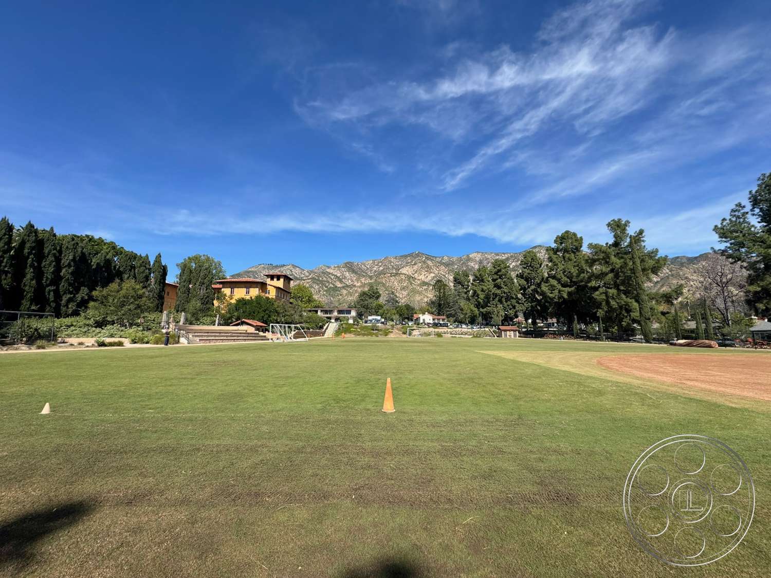 School 20 - exterior, surrounding trees, mountain view, two-story home, vertical wood paneling, landscape setting, green grass field, architectural details of buildings, residential buildings with stucco siding