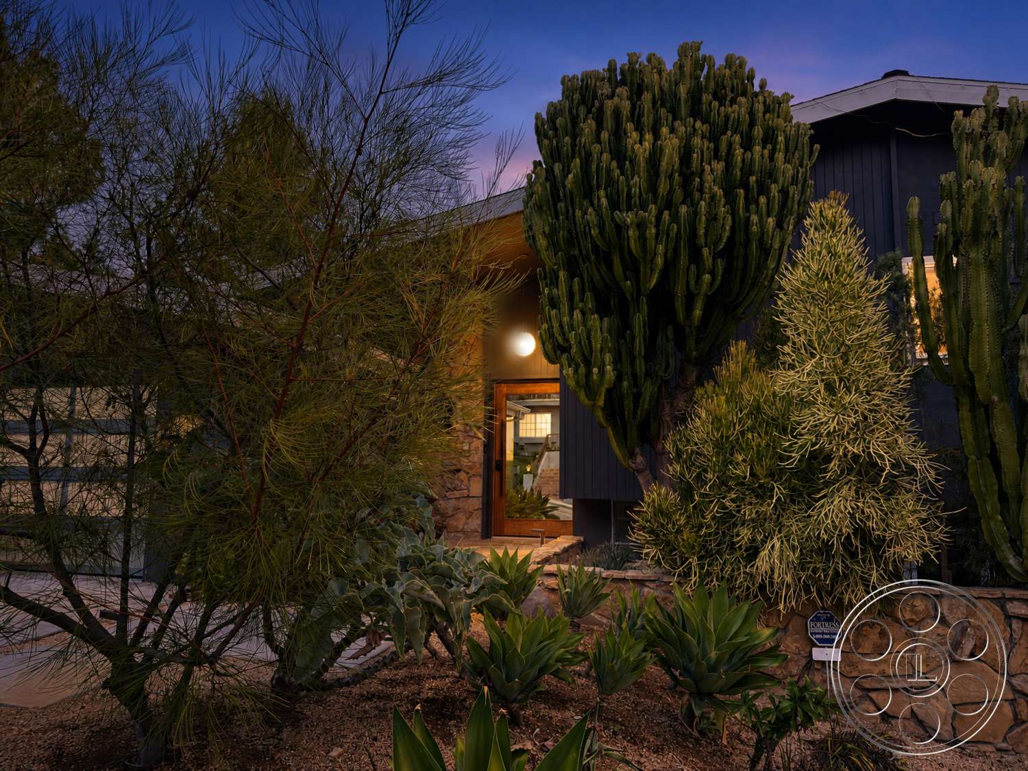 Americana 435 - large windows, exterior, modern architectural style, desert landscaping, natural stone path, succulent plants, outdoor pathway, cactus garden, sandy soil, mature shrubs, wooden entry door, flat roof structure, stone wall cladding, exposed wooden elements
