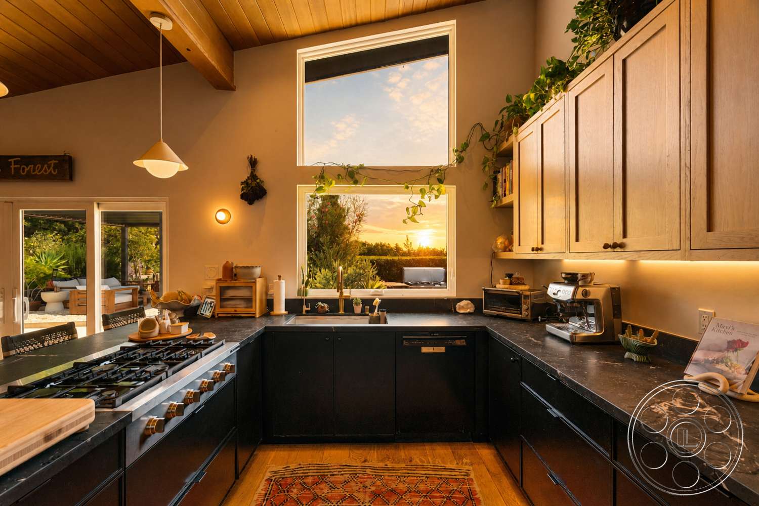 Americana 435 - gas cooktop, open concept layout, floor-to-ceiling windows, sunset view, black granite countertops, indoor plant decor, modern kitchen design, wood beam ceiling, hardwood kitchen flooring, minimalist lighting fixtures, light oak kitchen cabinets