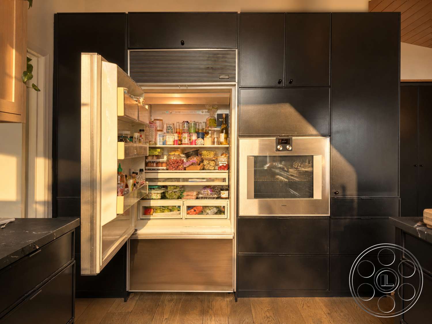 Americana 435 - natural light, clean lines, minimalist design, wooden flooring, open space layout, black cabinetry, modern architectural style, stainless steel refrigerator, built-in oven, gourmet kitchen, interior kitchen, sleek kitchen appliances