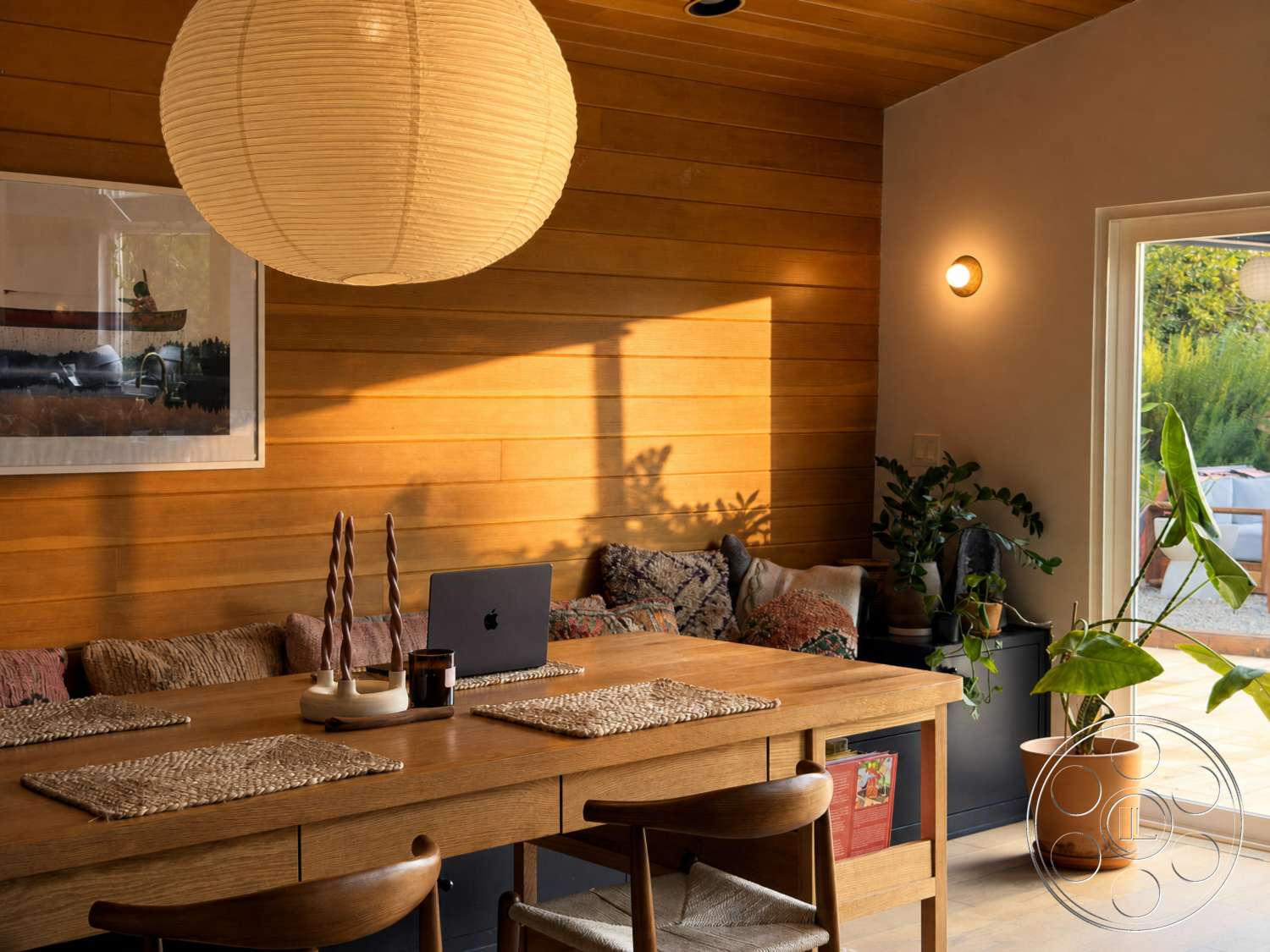 Americana 435 - contemporary interior design, modern dining area, indoor potted plant, wood paneling wall treatment, glass door leading to outdoor patio, plywood ceiling, large round paper pendant light, dining table with oak wood finish, woven placemats on dining table, fabric-covered bench seating