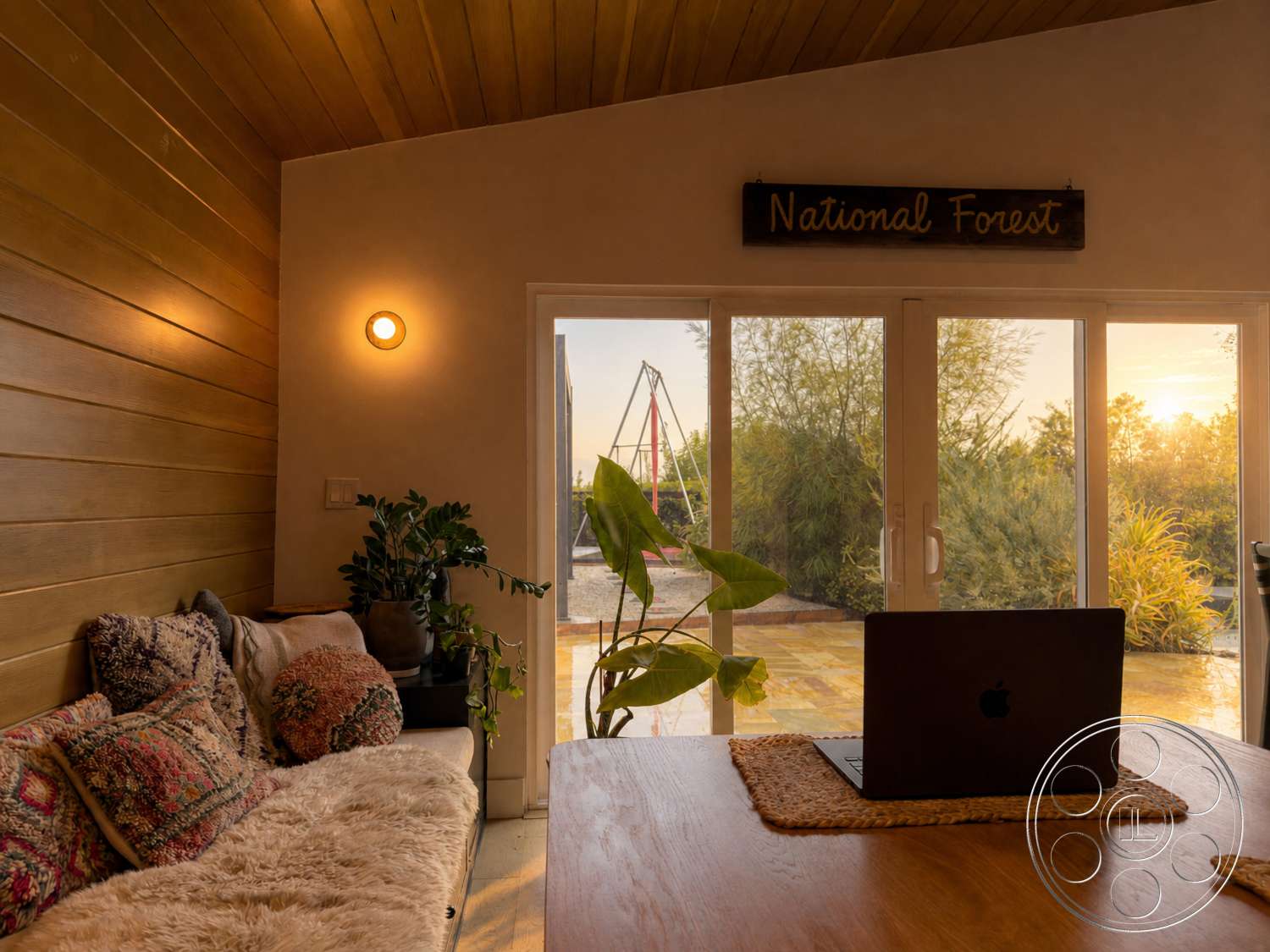 Americana 435 - natural light, indoor plant, large glass sliding doors, wooden dining table, surrounding greenery, textured throw pillows, sunset view, light wood ceiling, wood paneling walls, faux fur couch throw, woven table placemat, decorative swing set outdoors
