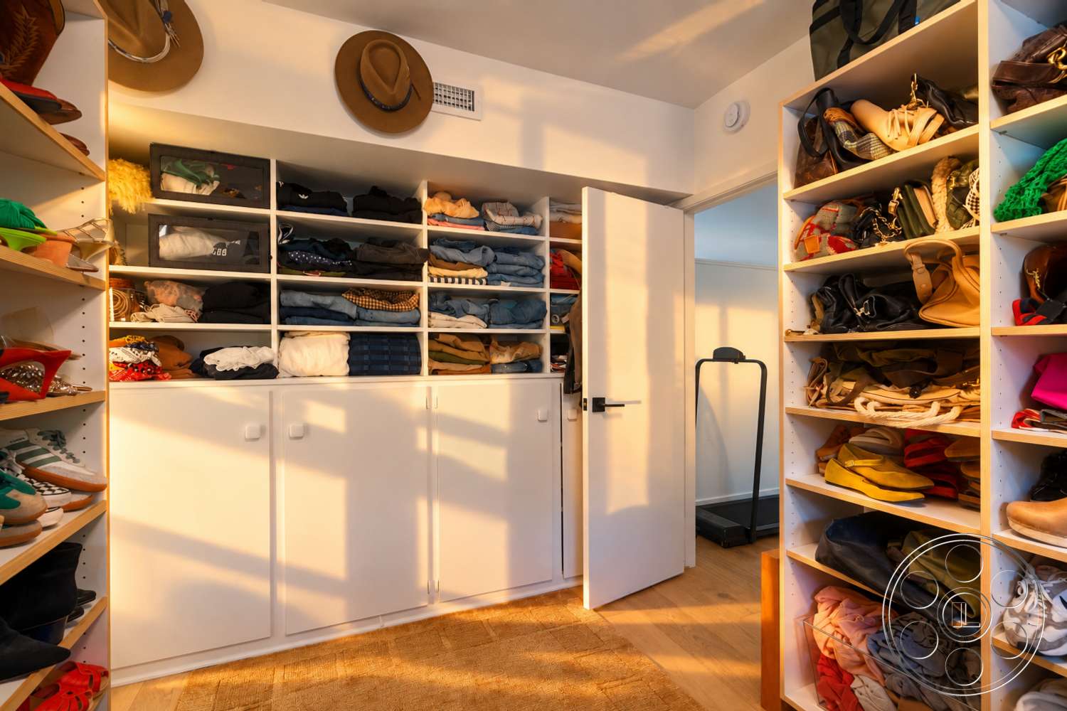 Americana 435 - wooden floor, light-filled space, white shelving units, folded clothing storage, cabinets with white doors, floor mat, hats displayed, organized shoe storage, shoe rack, clutter-free environment