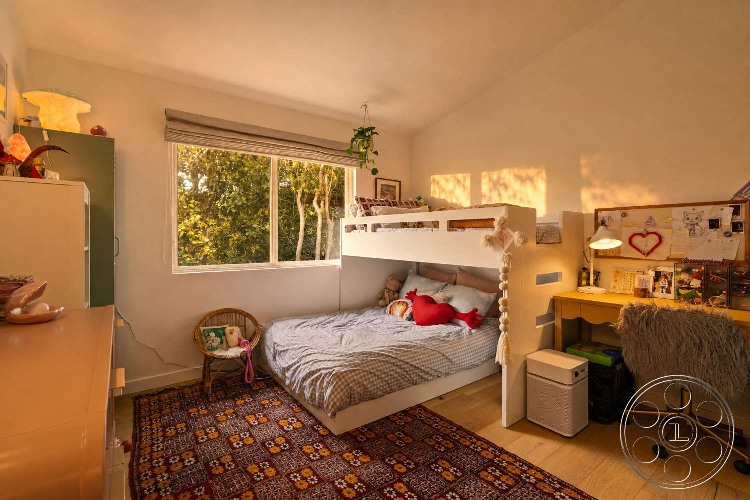 Americana 435 - bedroom, wooden bed frame, vinyl flooring, colorful wall decor, textured white plaster walls, modern wooden desk, large floor-to-ceiling window, geometric patterned area rug, light fixture with soft glow, gray checkered bedding, green window treatment, soft fur desk chair, bamboo plant