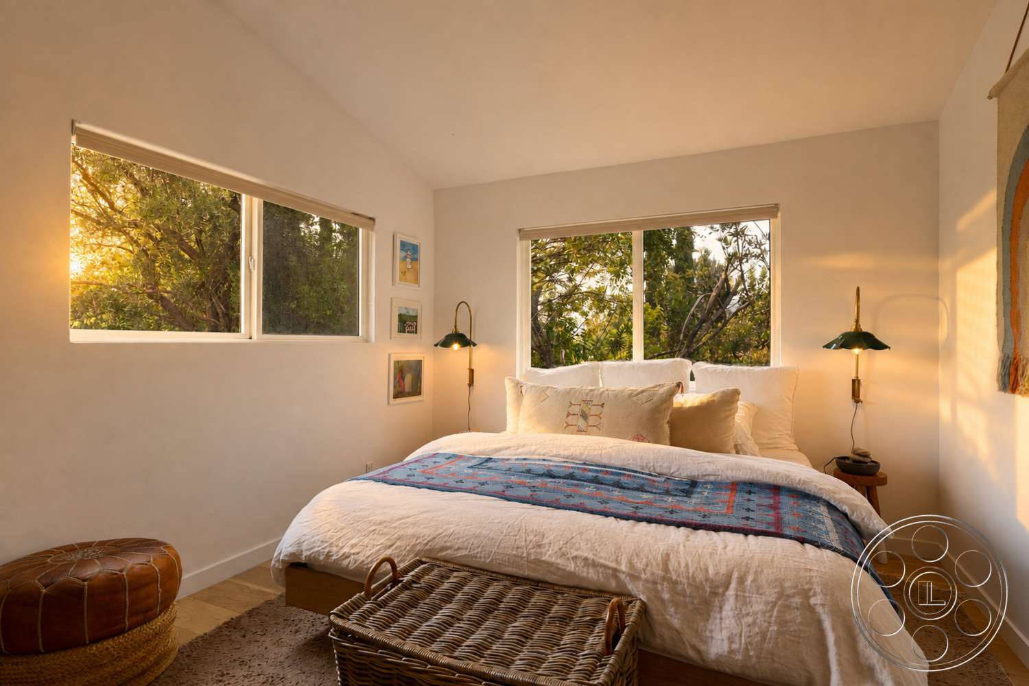 Americana 435 - minimalist decor, natural light, modern pendant lighting, artwork on walls, floor-to-ceiling windows, neutral wall color, vaulted ceiling, textured plaster walls, decorative throw pillows, earth-tone color palette, cozy bedroom setting, hardwood bedroom floors, woven basket storage, upholstered bed with white bedding, side table with lamp, rug on hardwood floor