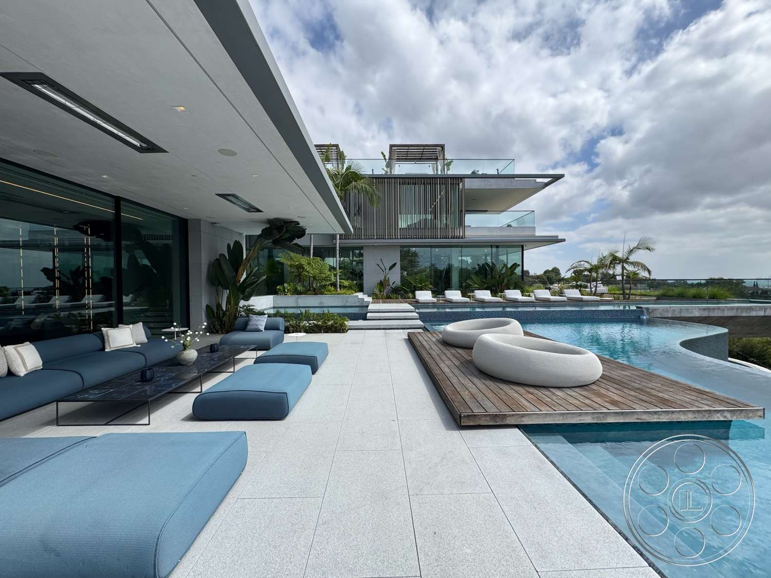 The Bellagio Estate - neutral color palette, large glass windows, textured concrete walls, modern landscaping, rectangular swimming pool, open-air living space, modern outdoor seating, contemporary architectural style, concrete patio flooring, tropical plant accents, stainless steel pool edge, wooden pool deck, luxury poolside loungers, horizontal wood slat screen, scenic waterfront view