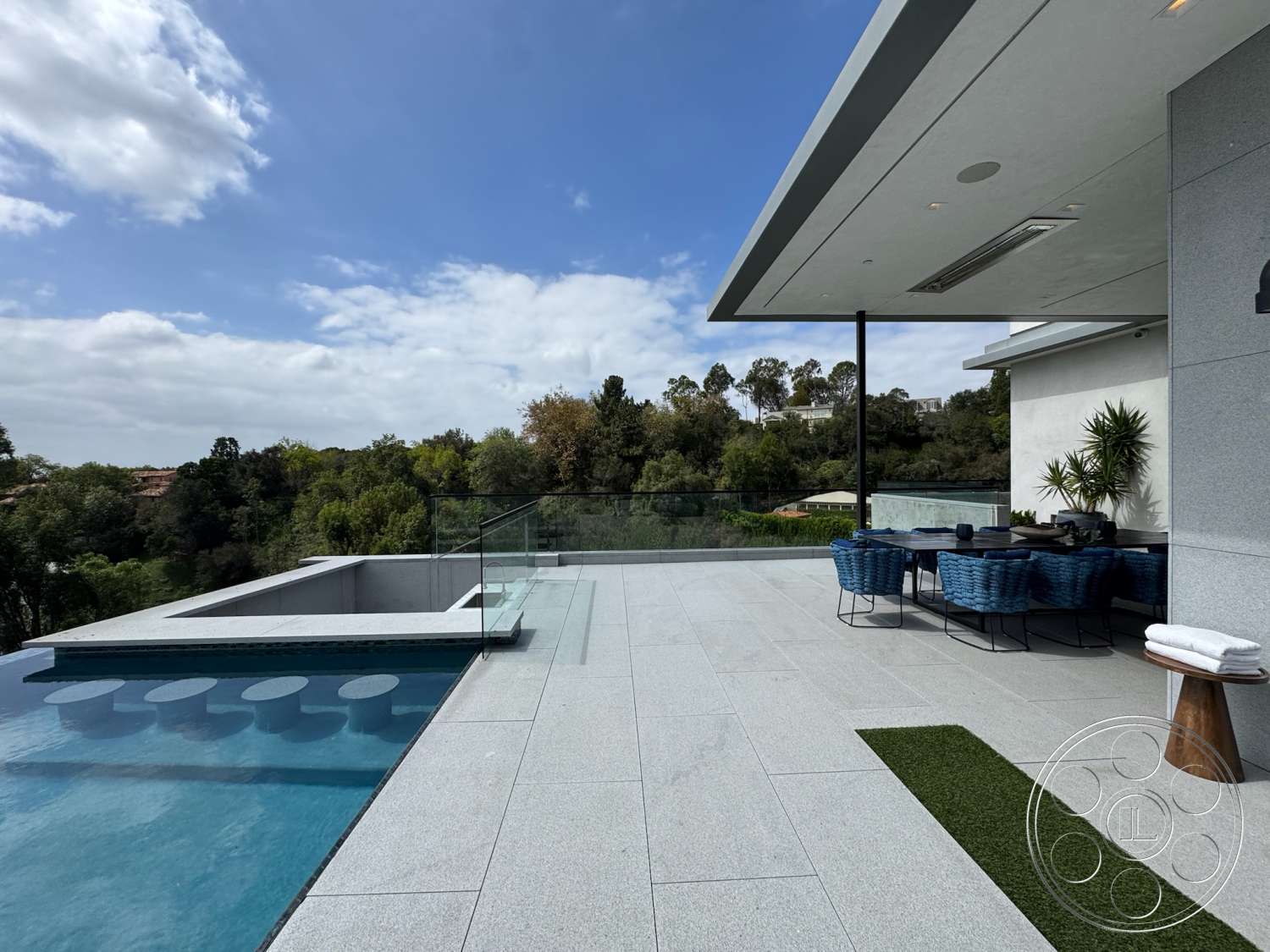 The Bellagio Estate - exterior, glass railing, contemporary architecture, outdoor lounge chairs, decorative potted plants, overhang roof, modern outdoor dining area, granite patio flooring, rectangular infinity pool, landscaped hillside view