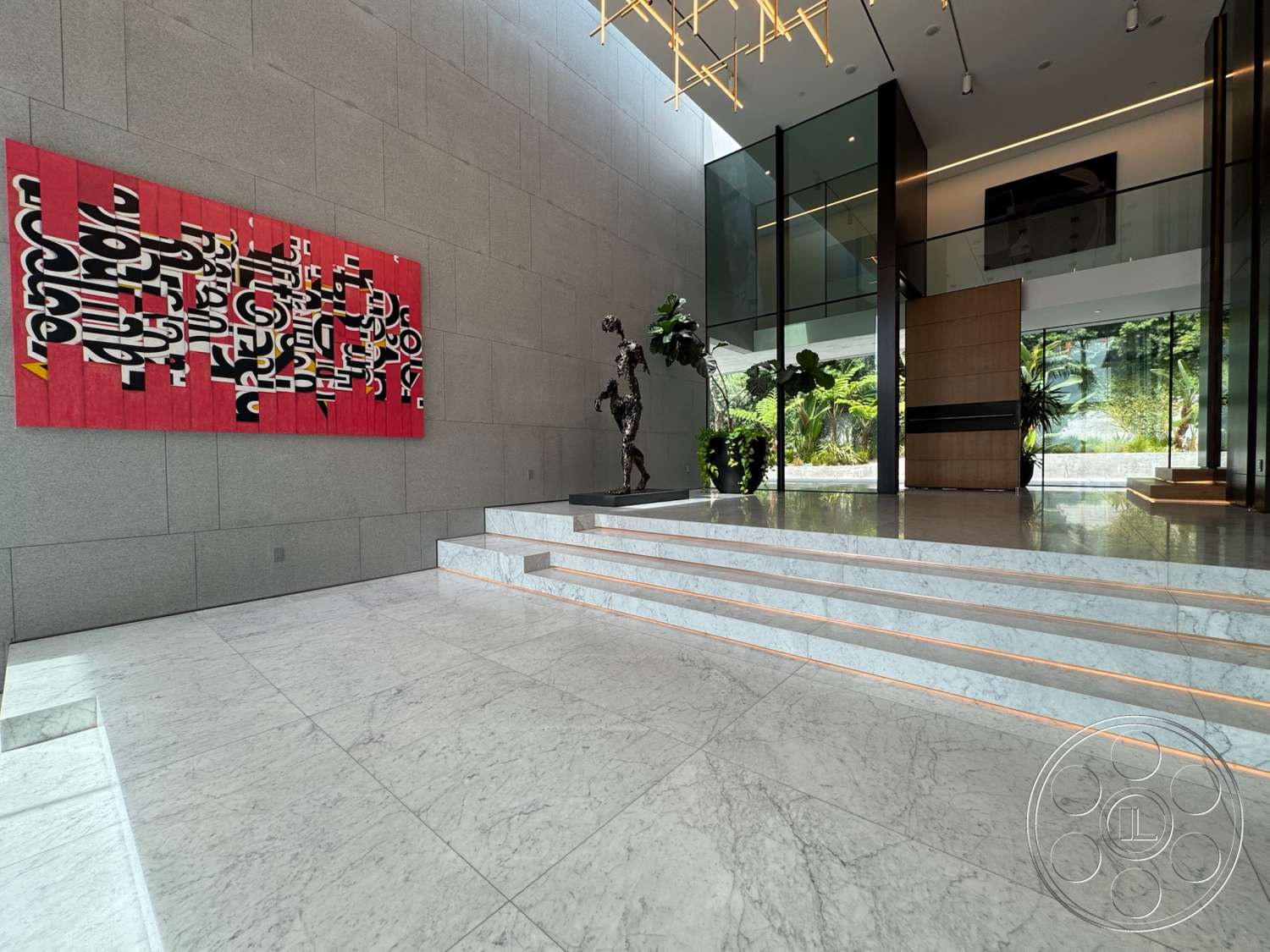 The Bellagio Estate - minimalist design, abstract wall art, concrete walls, glass partitions, planter with greenery, modern chandelier, marble floor, marble staircase, open foyer space, sculpture feature