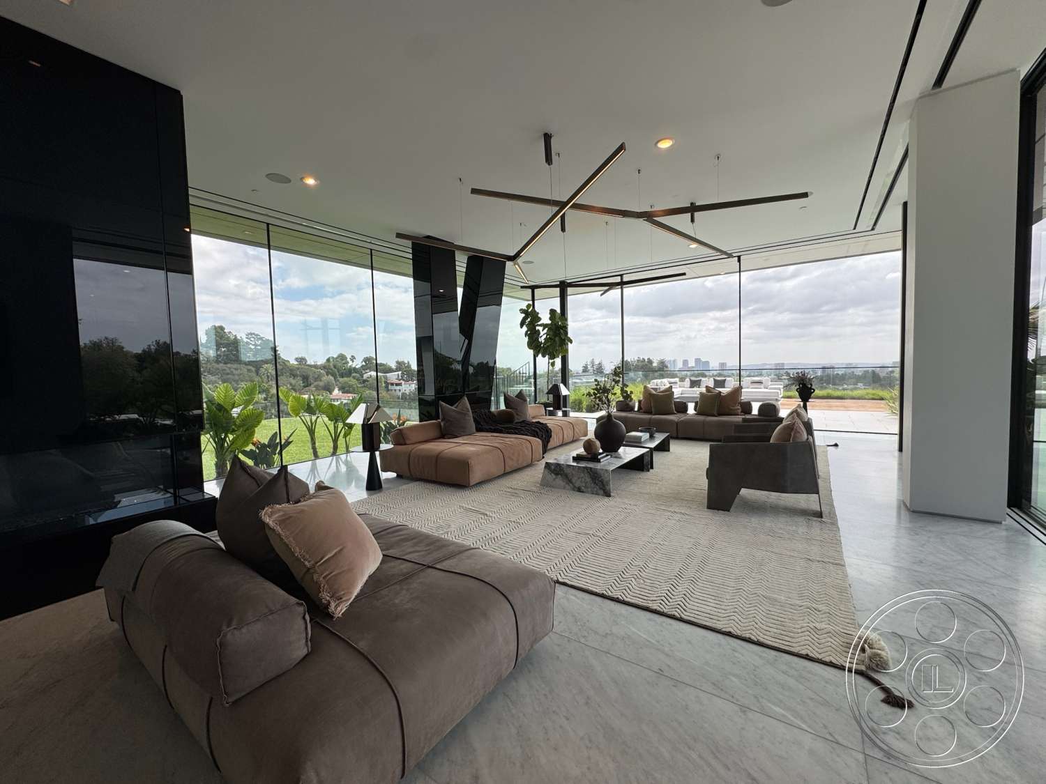 The Bellagio Estate - floor-to-ceiling windows, green indoor plants, marble flooring, open living space, contemporary coffee table, minimalist pendant lighting, urban landscape view, modern sectional sofas, black stone feature wall, neutral upholstery fabric, zigzag pattern area rug