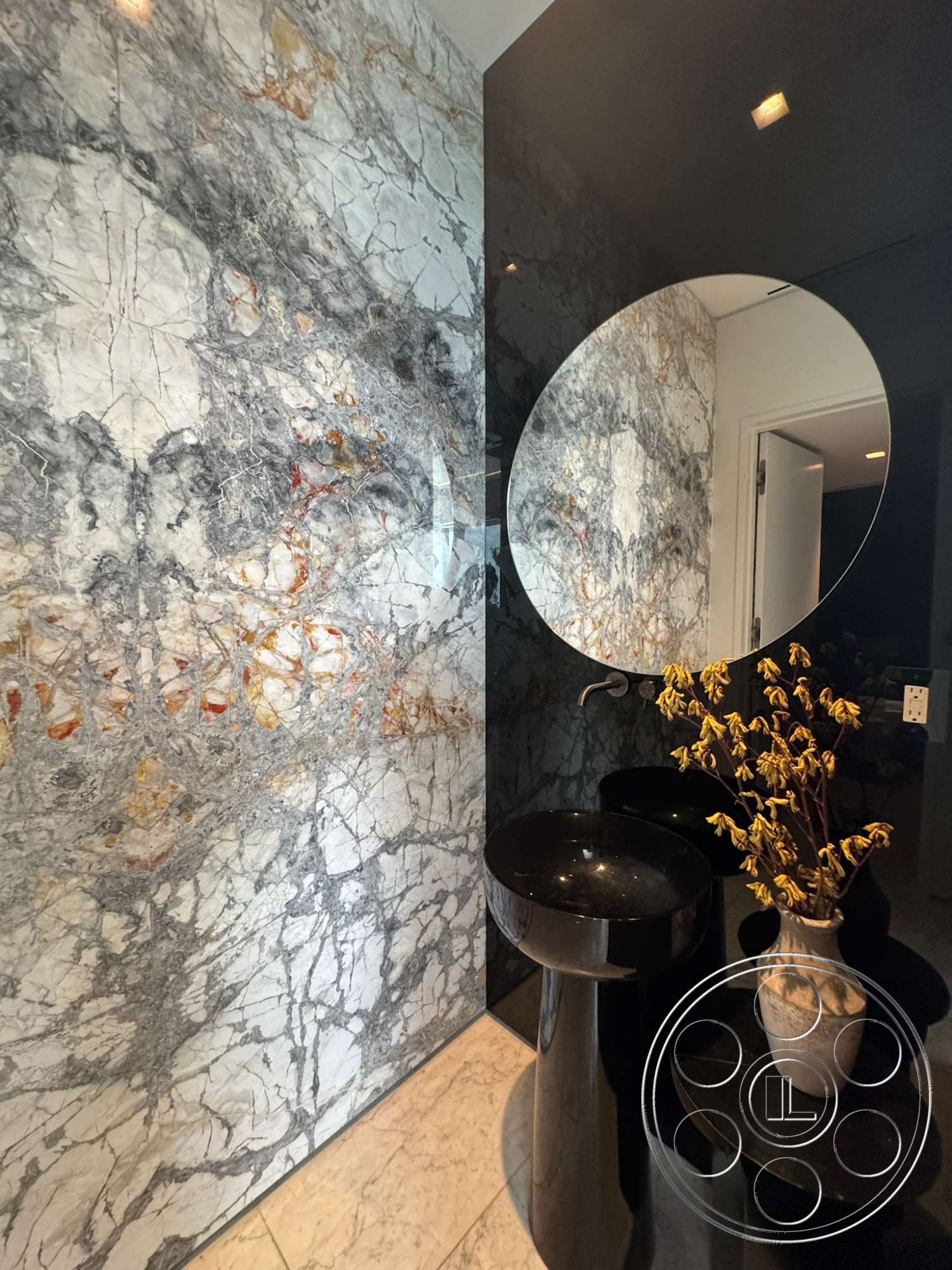 The Bellagio Estate - minimalist decor, modern design elements, polished marble flooring, dark color palette, textured stone accent wall, indirect lighting fixtures, marble wall treatment, black marble basin, round mirror with marble frame, floor-mounted washbasin