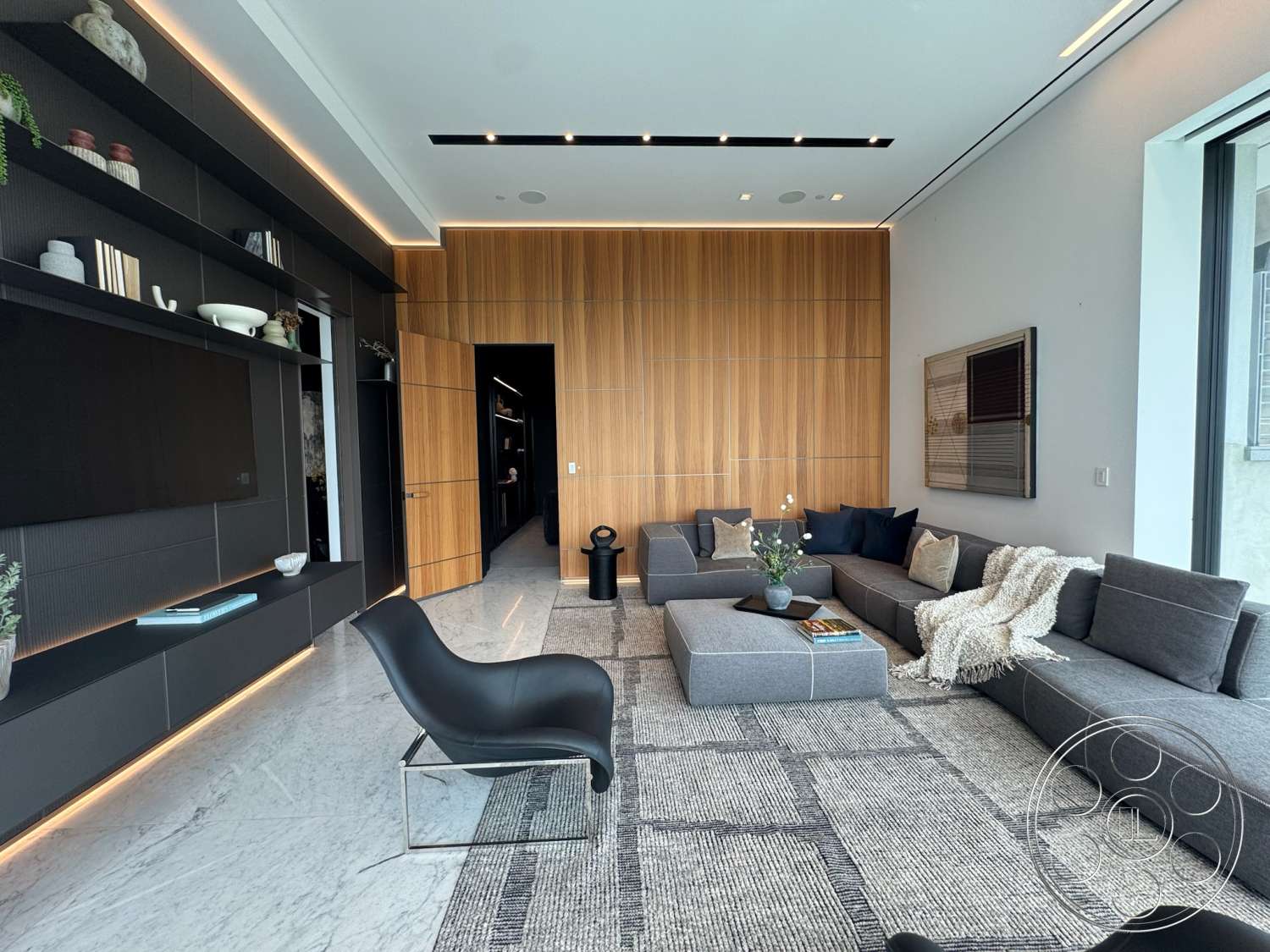 The Bellagio Estate - neutral color palette, contemporary furniture, open concept layout, floor-to-ceiling windows, black cabinetry, marble flooring, woven area rug, accent lighting, dark wood paneling