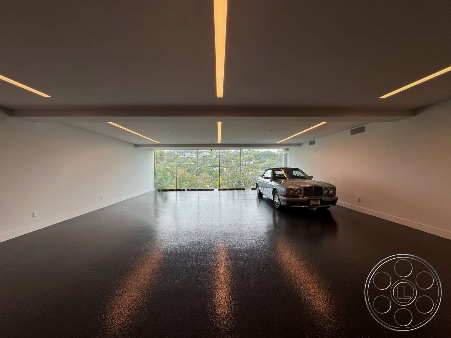 The Bellagio Estate - polished concrete flooring, open space layout, floor-to-ceiling windows, flat ceiling with recessed lighting, white painted walls, minimalist lighting fixtures, urban setting with hillside view