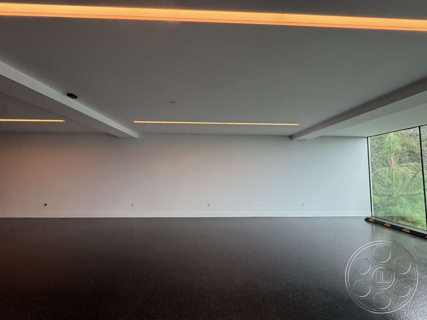 The Bellagio Estate - concrete flooring, open space layout, floor-to-ceiling windows, exposed ceiling beams, white painted walls, minimalist architectural style, ambient LED ceiling lighting