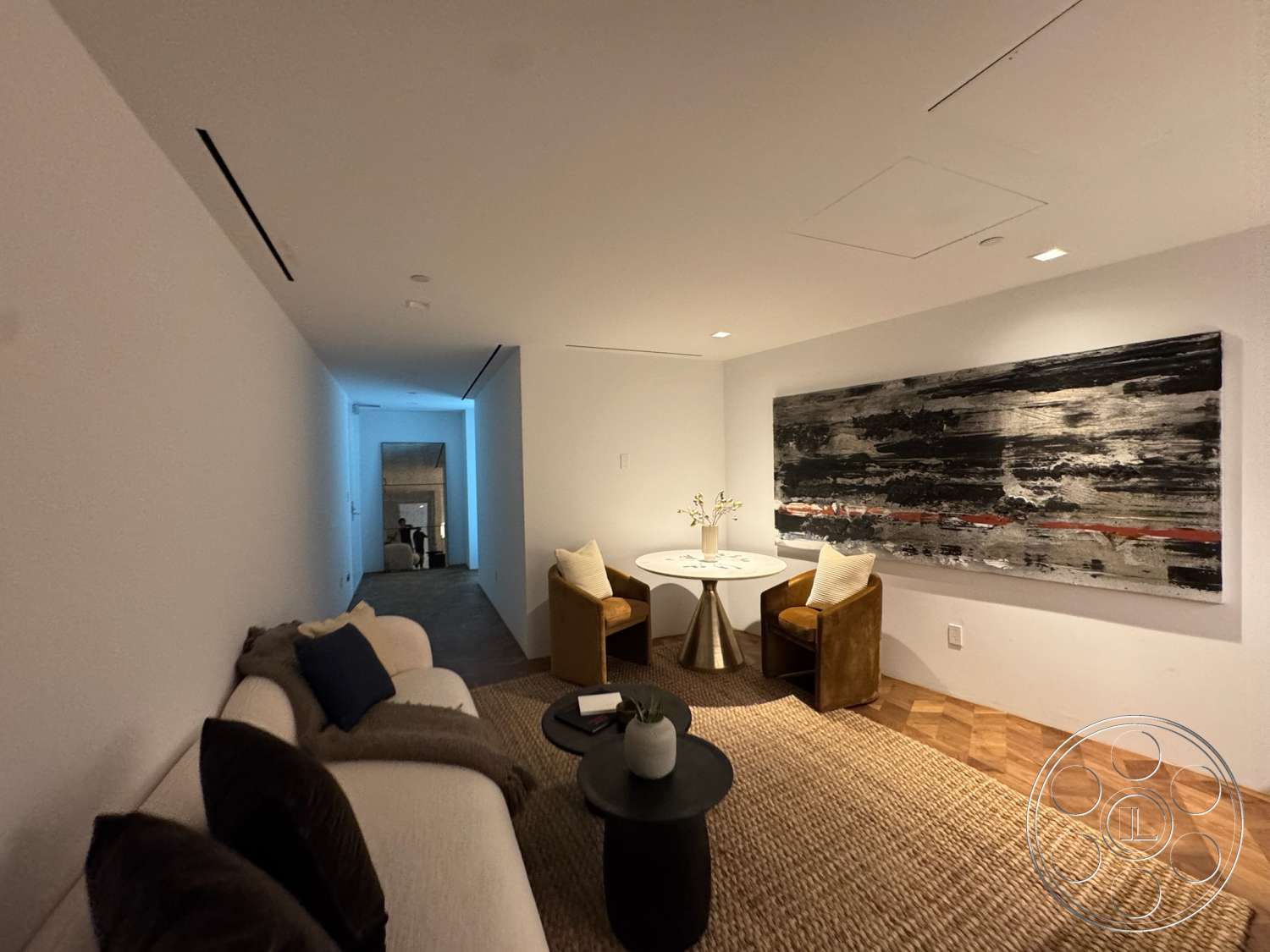 The Bellagio Estate - hardwood flooring, textured area rug, round dining table, recessed ceiling lights, white painted walls, modern artwork on wall, open layout living space, metallic table base, cushioned armchairs