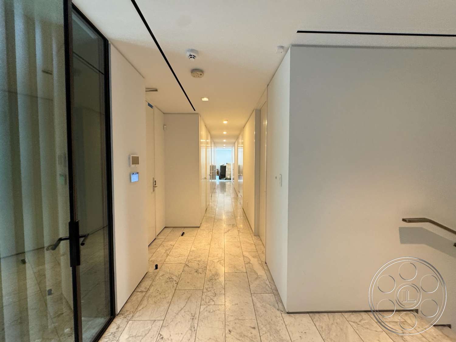 The Bellagio Estate - glass door, minimalist design elements, white painted walls, natural light from floor-to-ceiling windows, stainless steel stair railings, rectangular hallway layout, polished marble hallway floor, built-in closet doors, modern linear ceiling lights