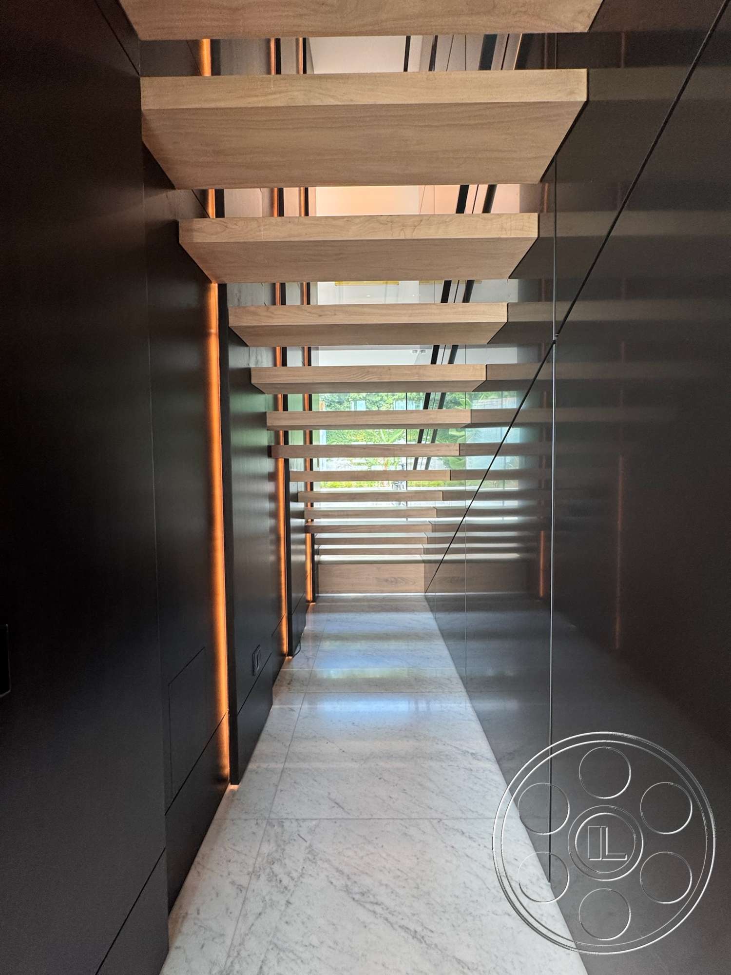 The Bellagio Estate - modern architectural style, linear LED lighting, marble flooring, glass stair railing, black wall paneling, floating wood staircase, open hallway design