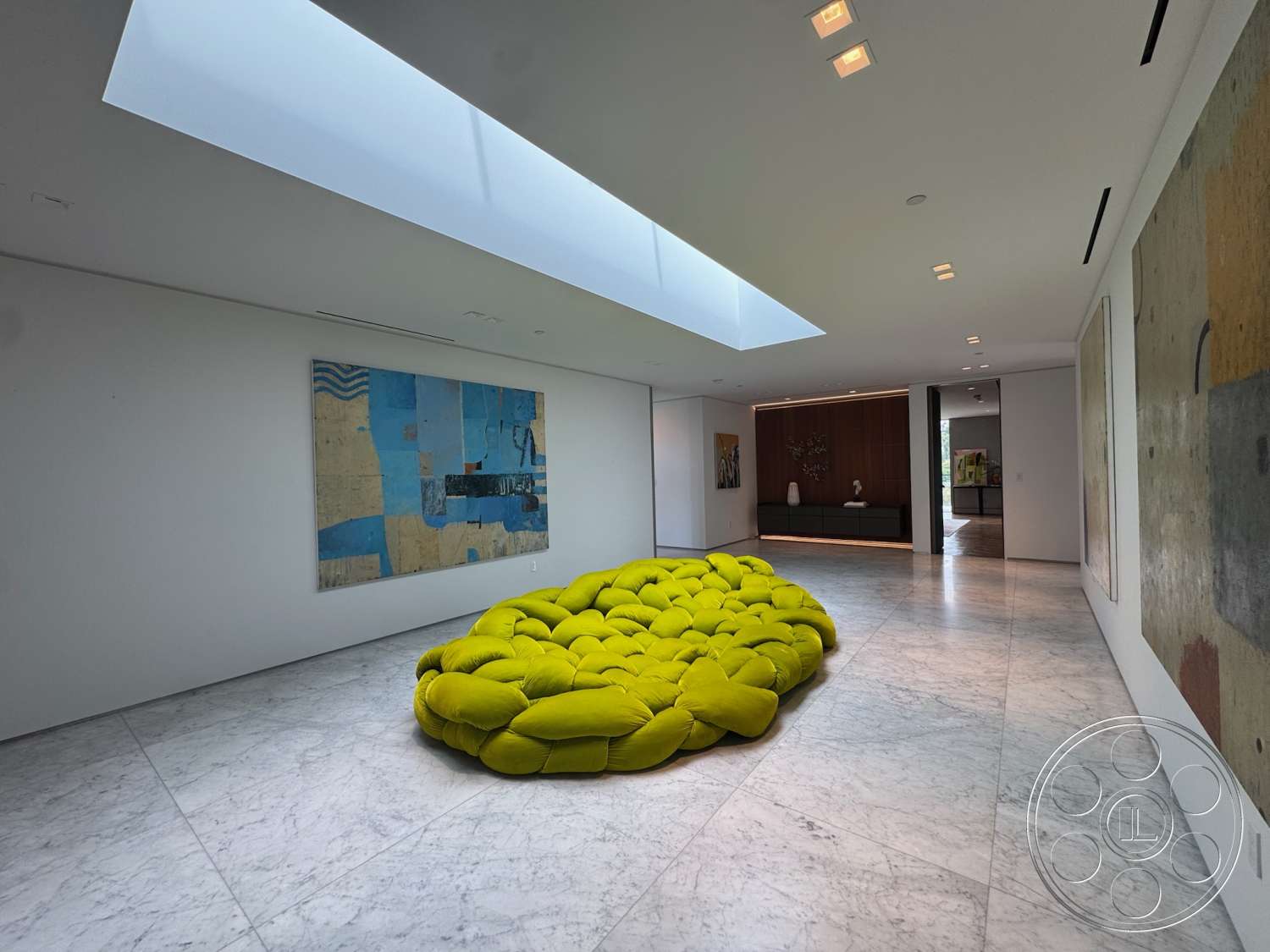 The Bellagio Estate - minimalist design elements, large open space, low-profile seating, marble flooring, textured wall treatments, geometric forms, modern lounge area, white painted walls, skylight ceiling, contemporary art pieces, natural light source