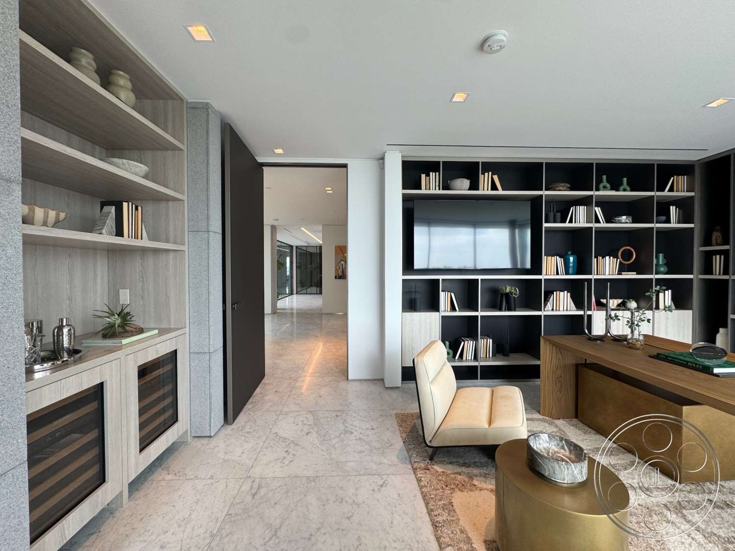 The Bellagio Estate - neutral color palette, textured area rug, floor-to-ceiling windows, built-in wine storage, marble flooring, golden coffee table, minimalist decor elements, dark wood entry door, glass partition wall, industrial style lighting fixtures, open shelving unit, contemporary cabinetry, modern accent chair, light wood accent shelves, geometric bookshelf design