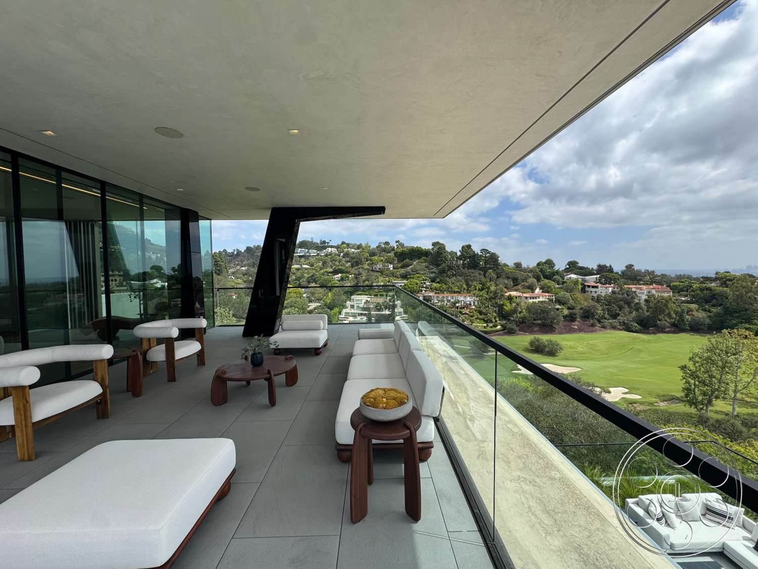The Bellagio Estate - exterior, lush greenery, glass railing, modern outdoor furniture, landscape view, open balcony, contemporary architectural style, slate patio flooring, concrete overhang, dark wood accent tables