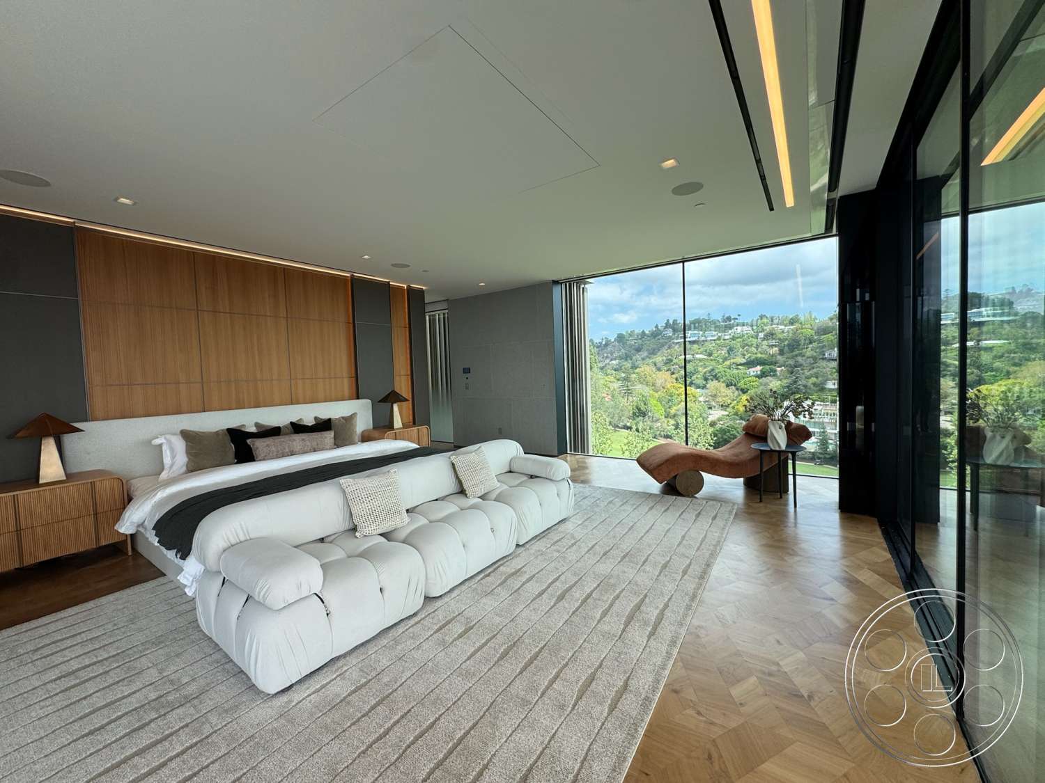 The Bellagio Estate - neutral color palette, textured area rug, open space layout, floor-to-ceiling windows, mountain view, wood panel accent wall, herringbone hardwood flooring, minimalist bedside lamps, contemporary bed design, modern sculpture chair