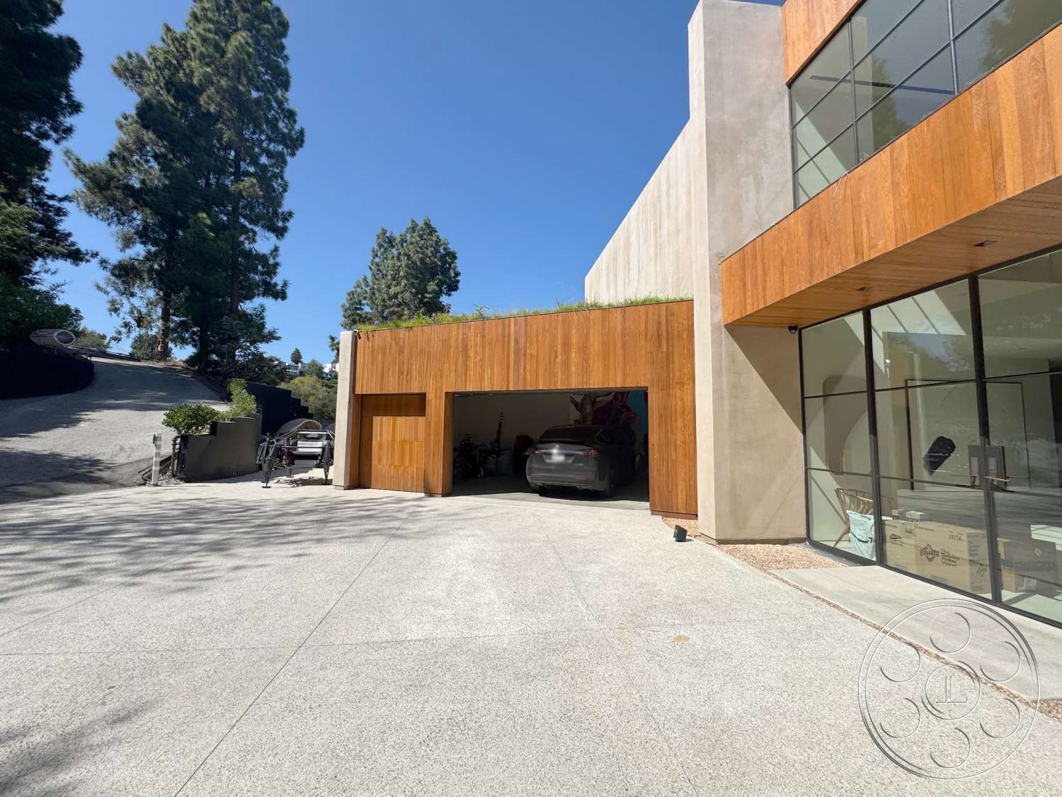 Modern 527 - exterior, flat roof, wood paneling, concrete walls, glass windows, landscaped front yard, textured concrete flooring, modern architectural style, concrete driveway, integrated landscaping, sloping driveway, exposed wood garage door, custom garage