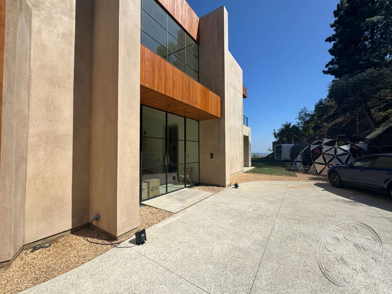 Modern 527 - natural light, exterior, modern architecture, minimalist design, floor-to-ceiling windows, gravel landscaping, concrete driveway, stucco walls, angular shapes, wood accent paneling