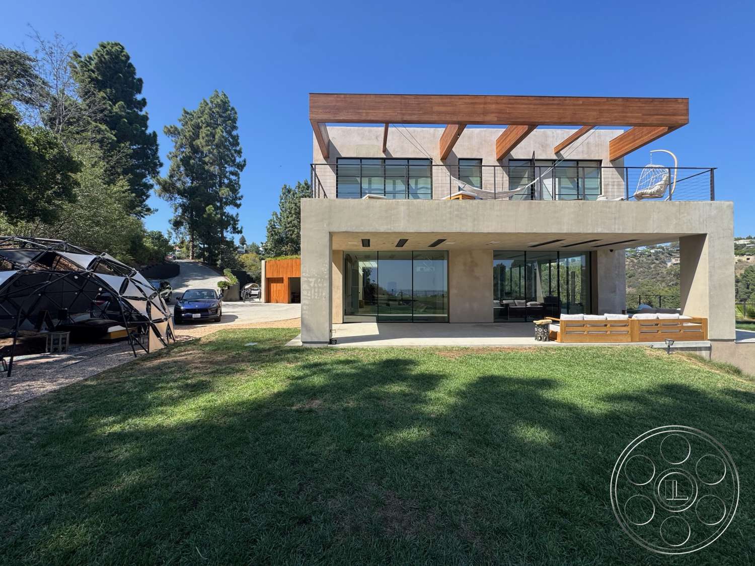 Modern 527 - exterior, modern architecture, flat roof, glass railing, modern outdoor furniture, concrete walls, urban setting, floor-to-ceiling windows, grass lawn, gravel driveway, hillside location, rectangular layout, wood beam ceiling, open patio area, large outdoor terrace
